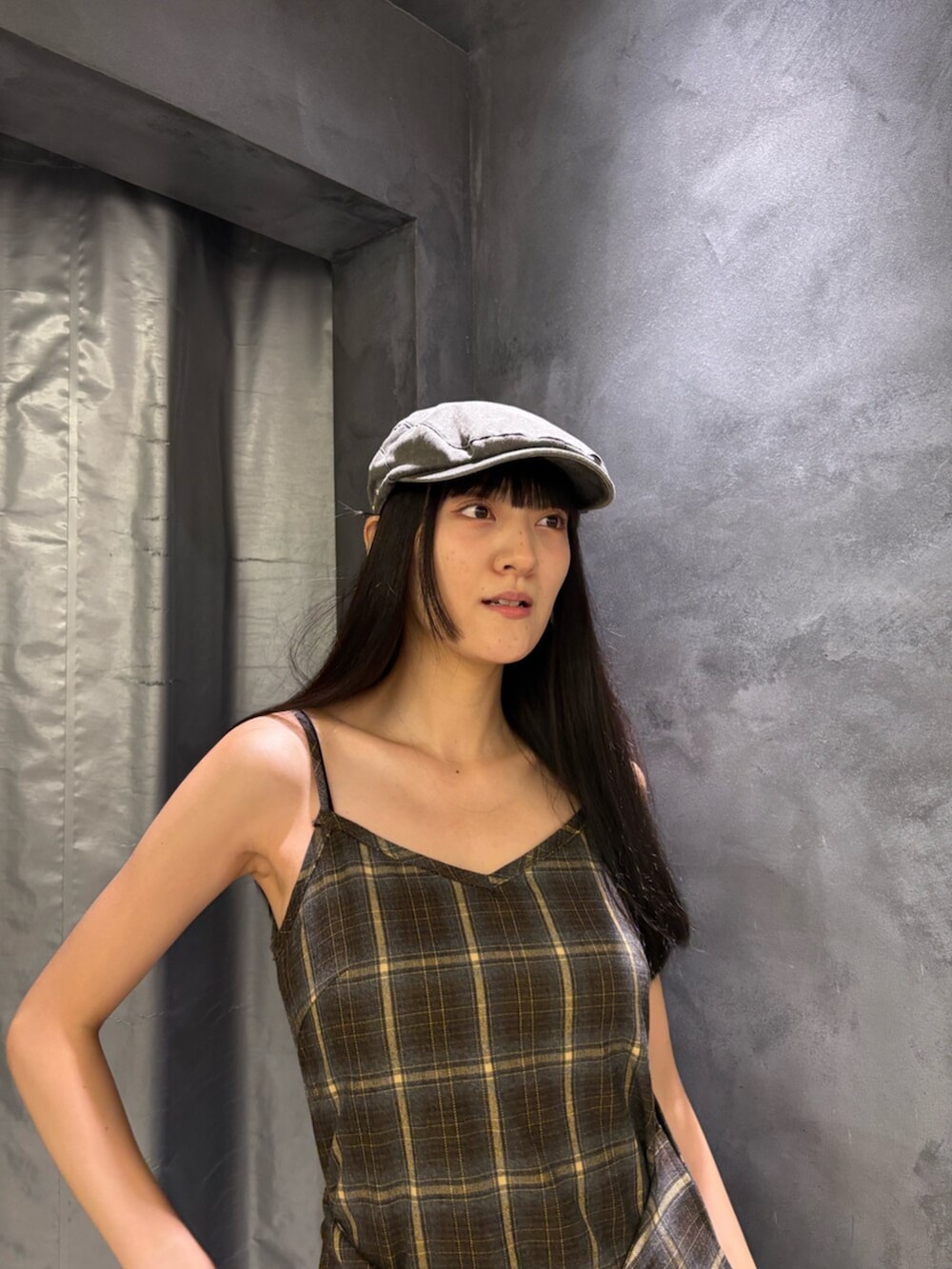 グリーン系のワンピース、ブラック系のブーツ、グレー系のハンチング/ベレー帽を着用したレディースの夏コーディネートの6枚目の写真