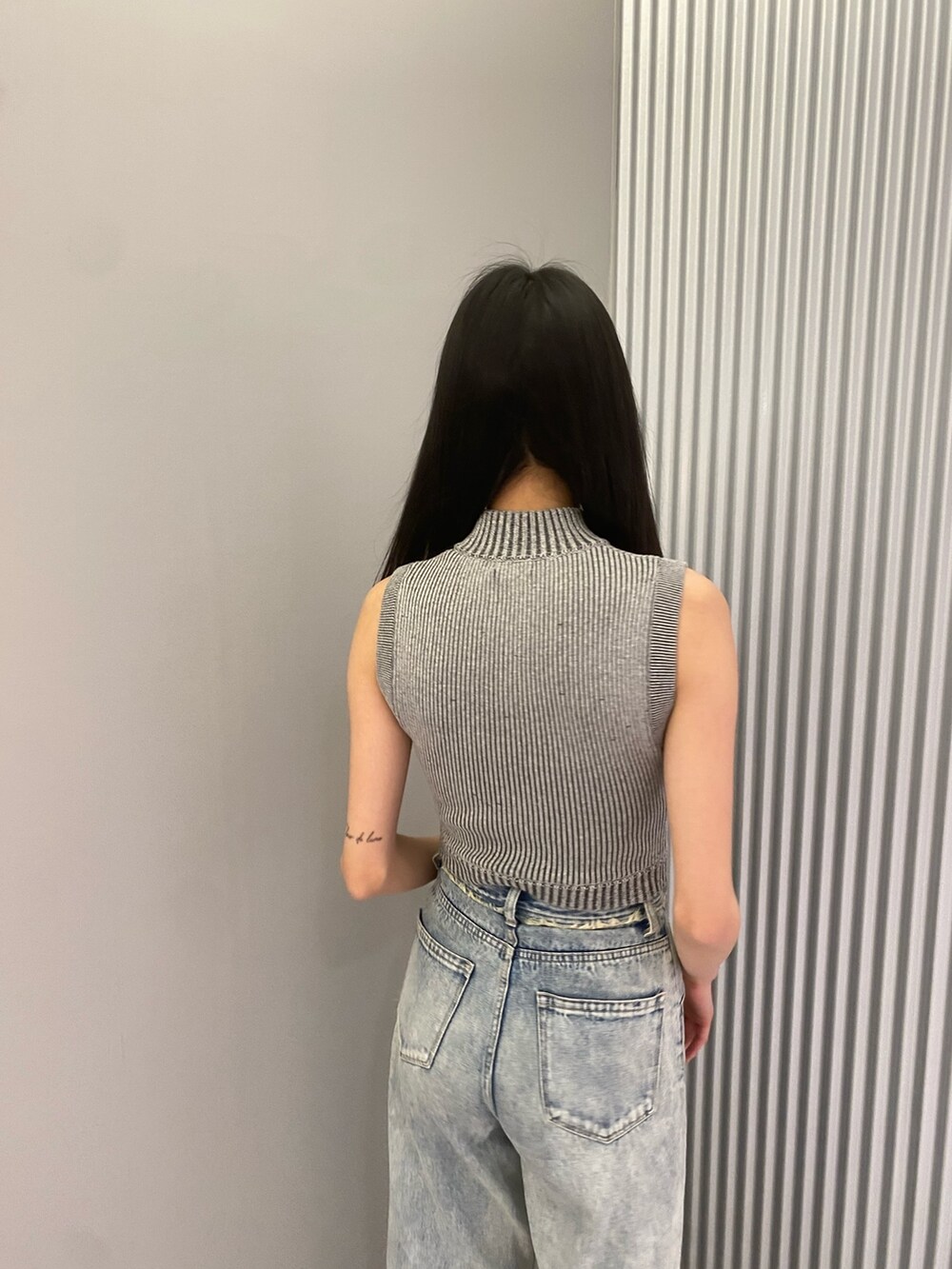 ブルー系のデニムパンツ、グレー系のニット/セーター、ブラック系のサンダルを着用したレディースの春コーディネートの6枚目の写真