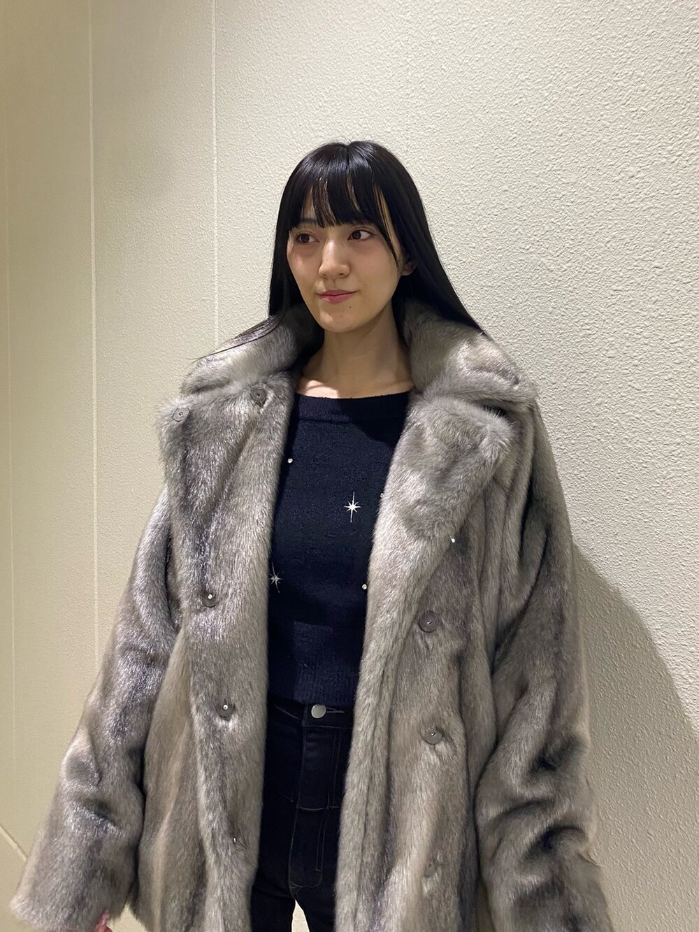 ブラック系のデニムパンツ、ブラック系のブーツ、ブラック系のニット/セーターを着用したレディースの冬コーディネートの6枚目の写真