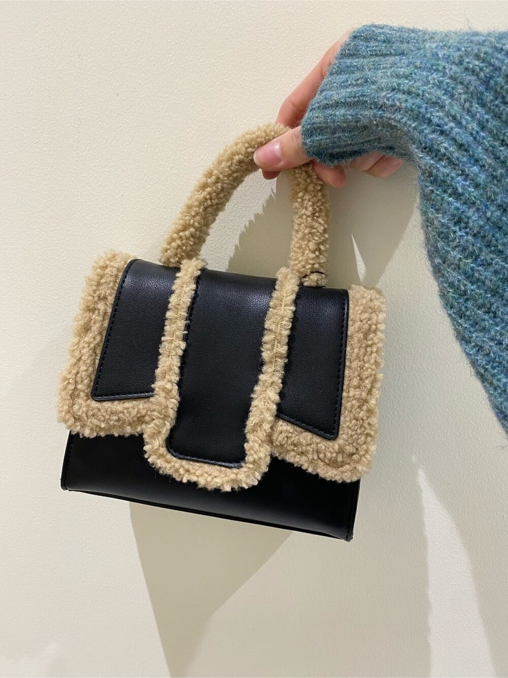 ブラック系のハンドバッグ、ブルー系のニット/セーター、ブラック系のその他パンツを着用したレディースの秋コーディネートの7枚目の写真