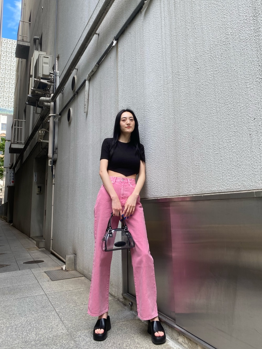 ピンク系のデニムパンツ、ブラック系のTシャツ/カットソー、その他のハンドバッグを着用したレディースの春コーディネートの2枚目の写真