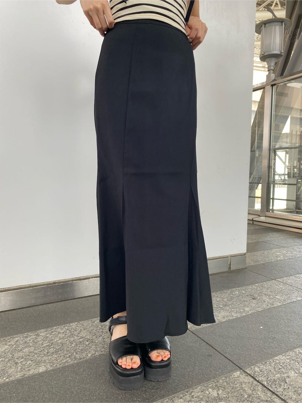 ブラック系のサンダル、ブラック系のスカート、その他のTシャツ/カットソーを着用したレディースの夏コーディネートの3枚目の写真