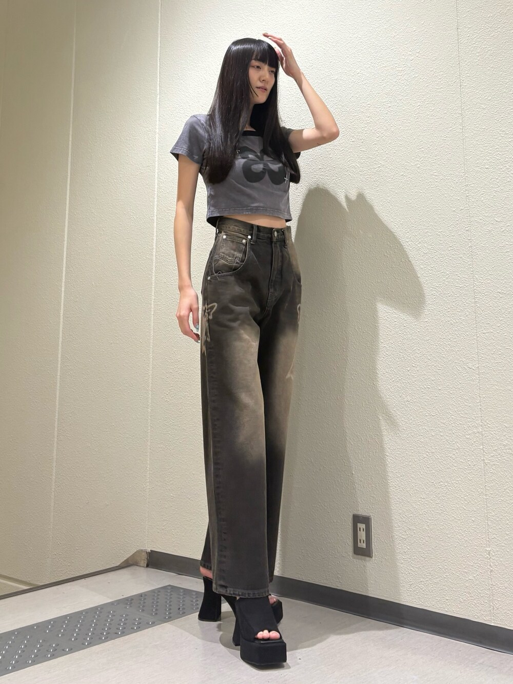 ブラック系のデニムパンツ、ブラック系のサンダル、グレー系のTシャツ/カットソーを着用したレディースの夏コーディネートの4枚目の写真