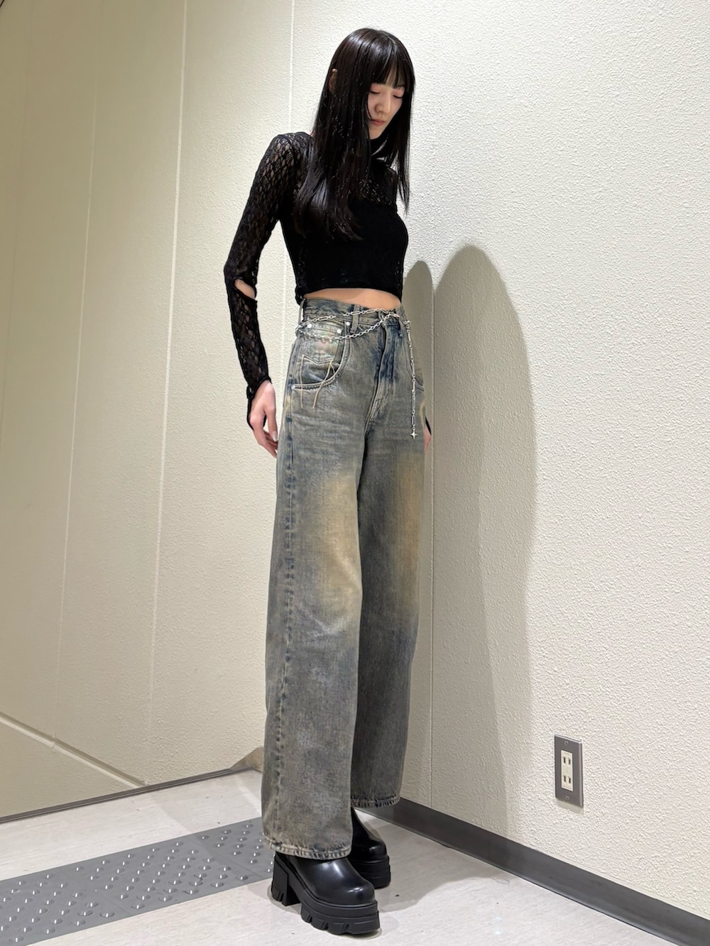 ブルー系のデニムパンツ、ブラック系のTシャツ/カットソー、ブラック系のブーツを着用したレディースの春コーディネートの6枚目の写真