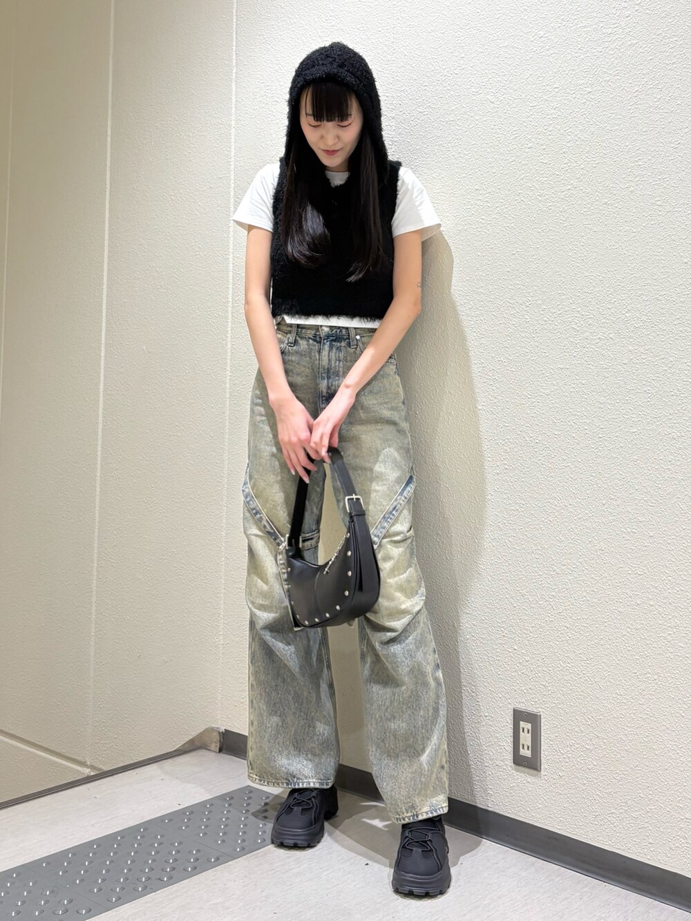 ブルー系のデニムパンツ、ブラック系のハンドバッグ、ホワイト系のTシャツ/カットソーを着用したレディースの春コーディネートの2枚目の写真