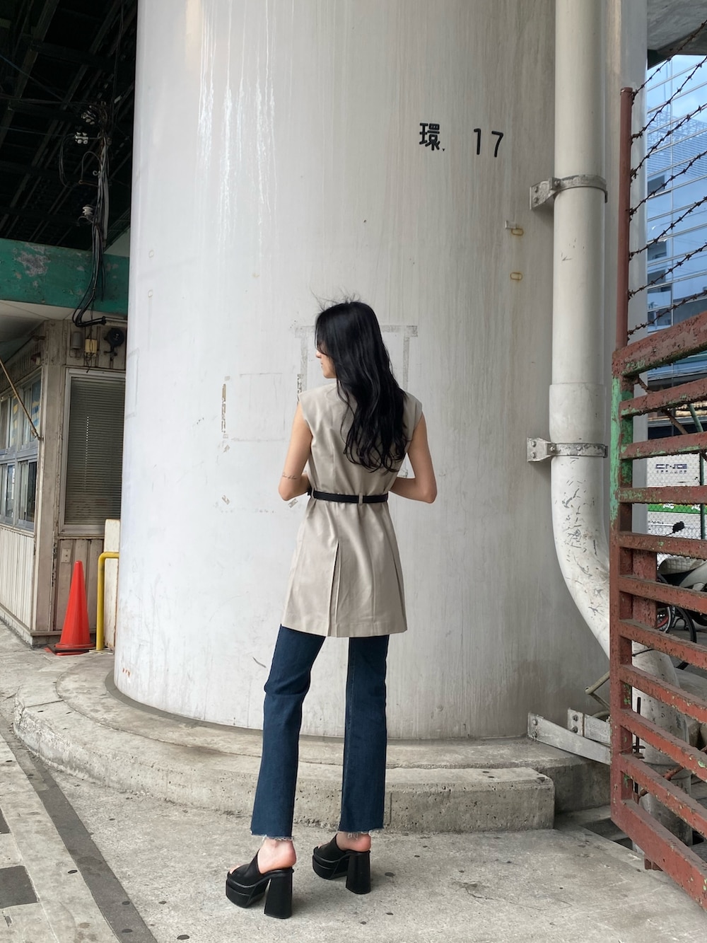 ホワイト系のワンピース、ブルー系のデニムパンツ、ブラック系のサンダルを着用したレディースの春コーディネートの3枚目の写真