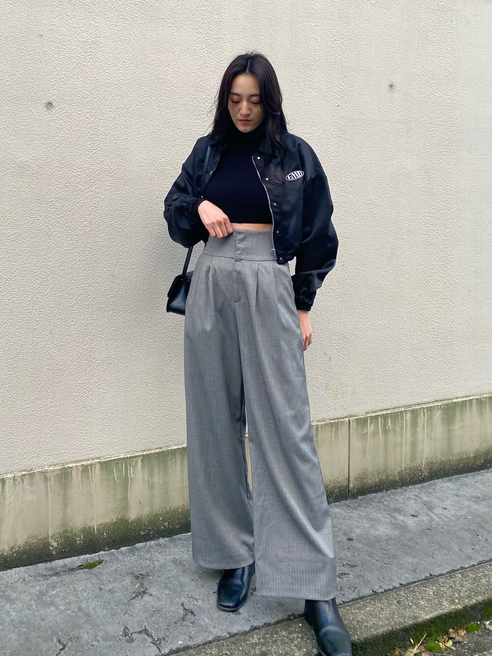 ブラック系のブルゾン、ブラック系のニット/セーター、グレー系のその他パンツを着用したレディースの冬コーディネートの2枚目の写真