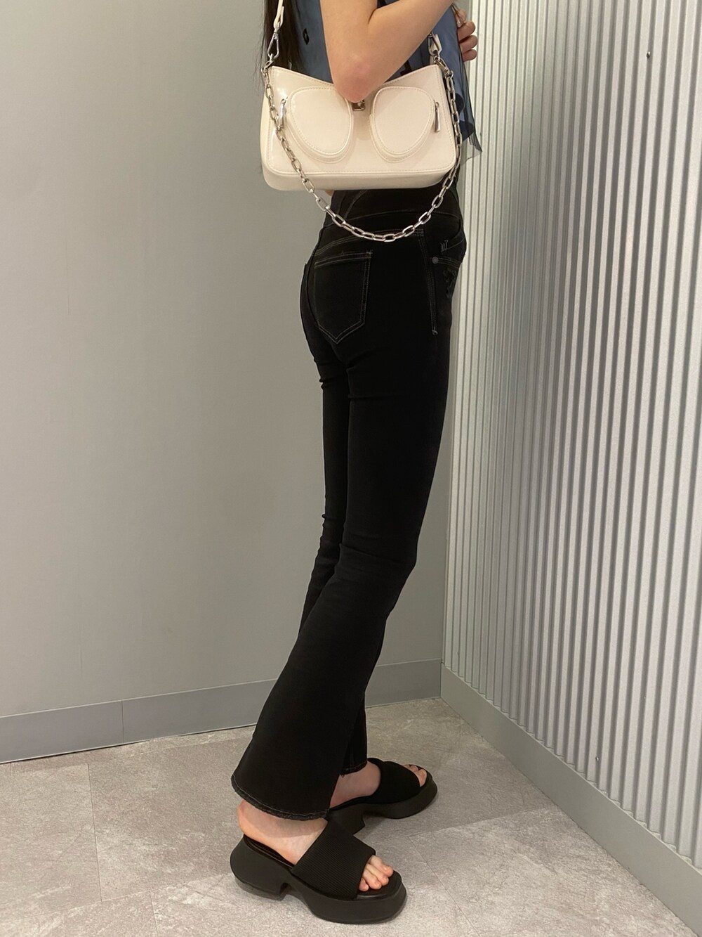 ブラック系のデニムパンツ、ブルー系のTシャツ/カットソー、ホワイト系のショルダーバッグを着用したレディースの春コーディネートの8枚目の写真