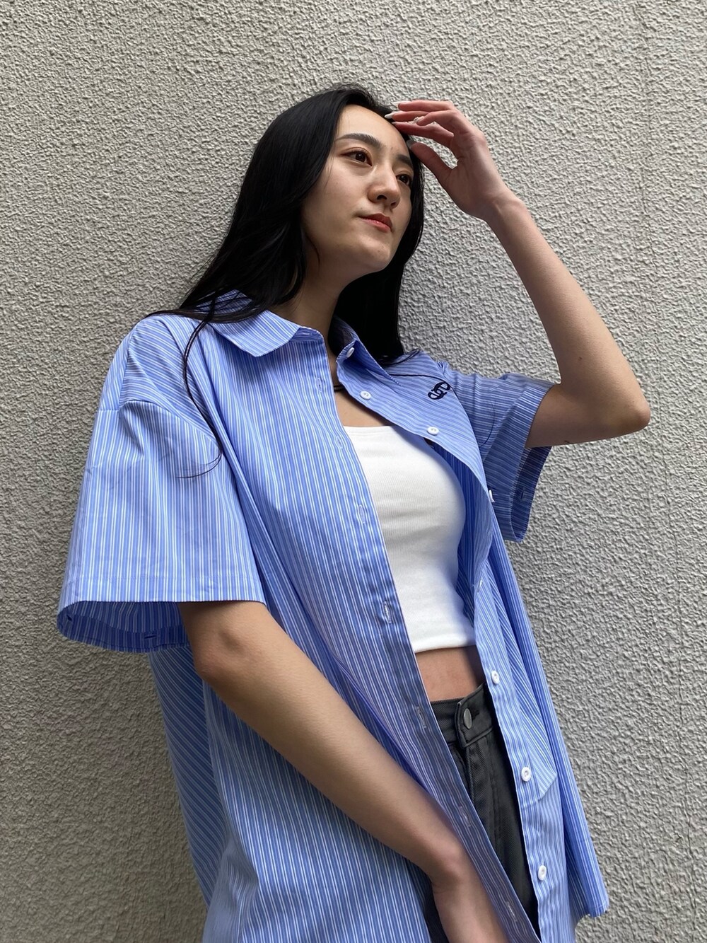 ブラック系のデニムパンツ、ブラック系のハンドバッグ、ブラック系のブーツを着用したレディースの春コーディネートの6枚目の写真