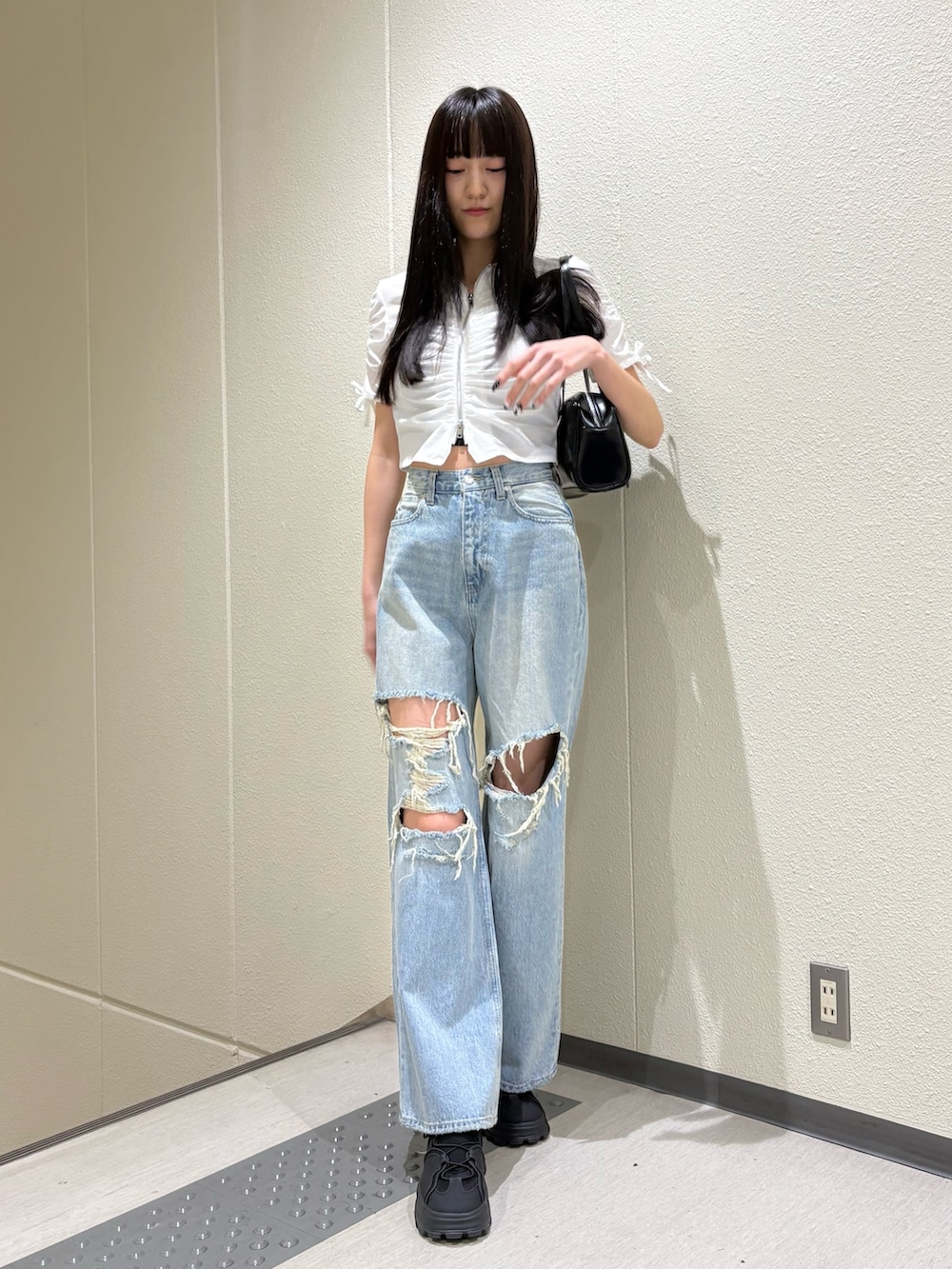 ブルー系のデニムパンツ、ホワイト系のシャツ/ブラウス、ブラック系のサンダルを着用したレディースの春コーディネートの4枚目の写真