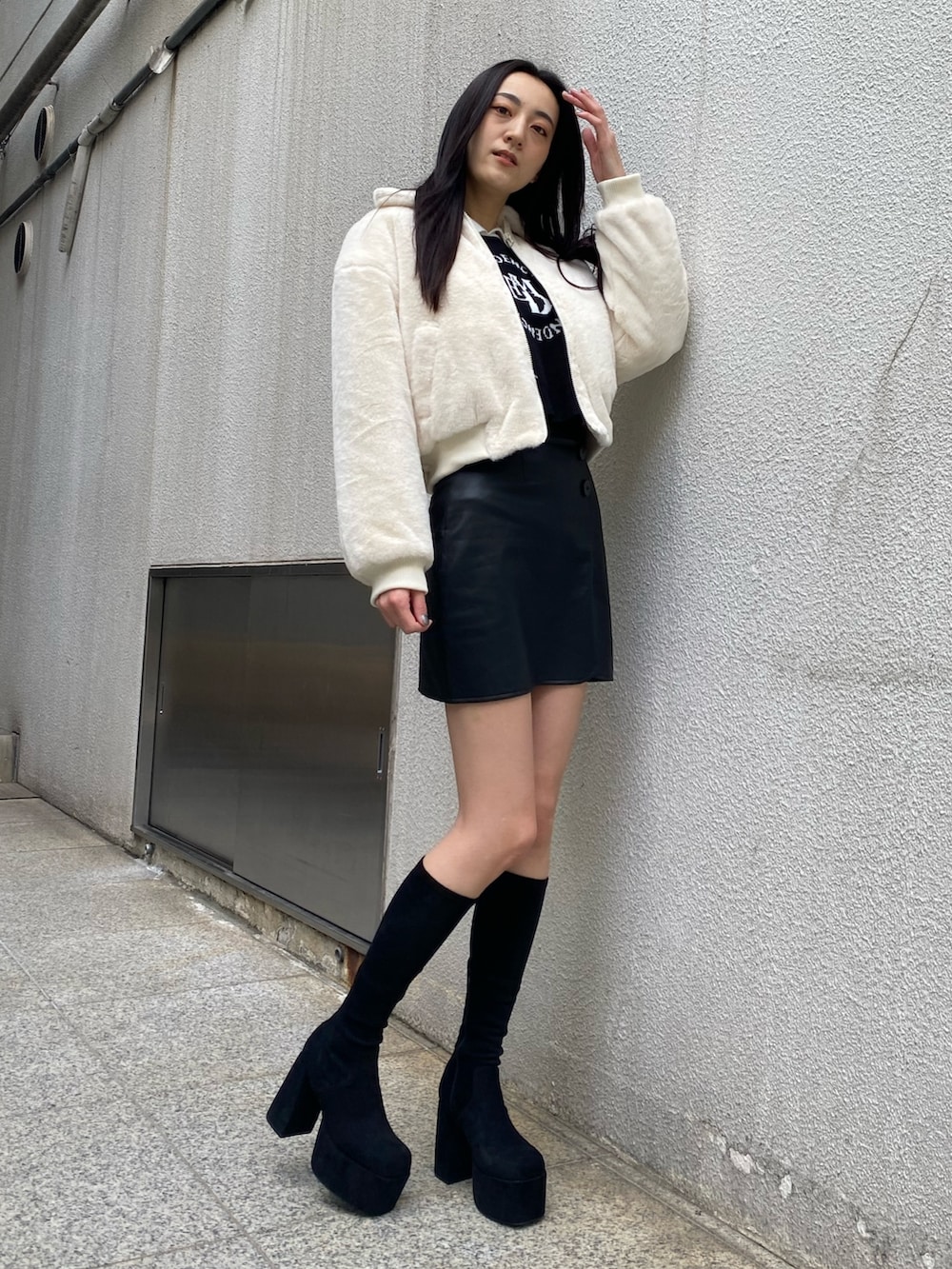 ブラック系のニット/セーター、ホワイト系のブルゾン、その他のスカートを着用したレディースの秋コーディネートの2枚目の写真