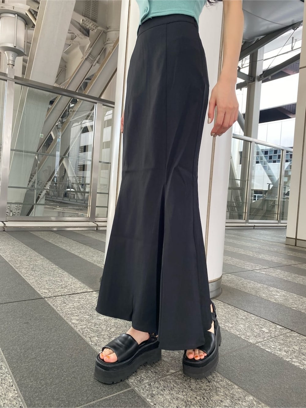 ブラック系のサンダル、ブラック系のスカート、ブルー系のTシャツ/カットソーを着用したレディースの夏コーディネートの6枚目の写真