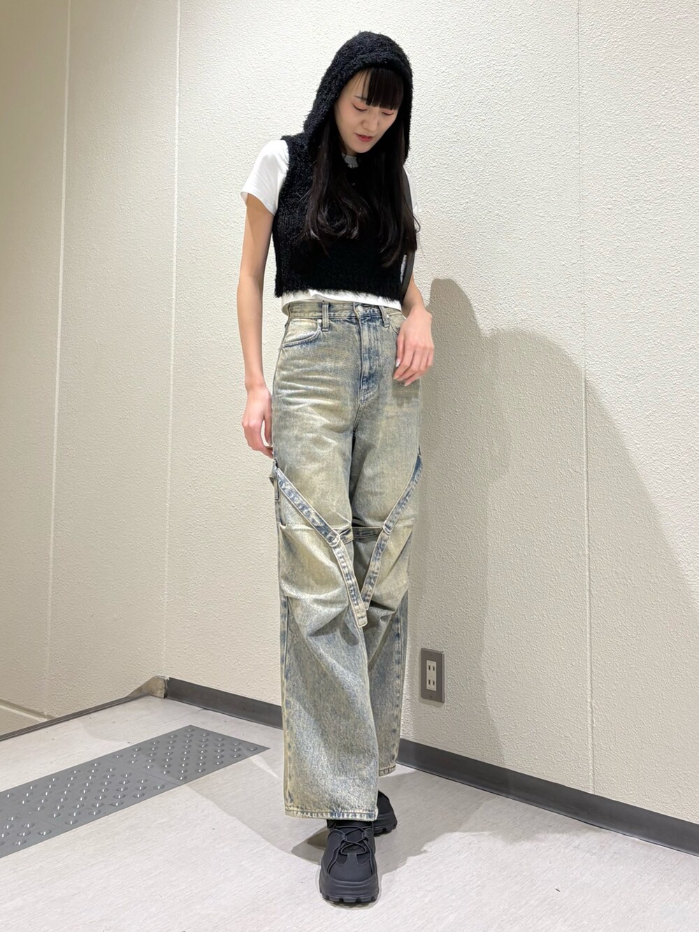 ブルー系のデニムパンツ、ブラック系のハンドバッグ、ホワイト系のTシャツ/カットソーを着用したレディースの春コーディネートの6枚目の写真