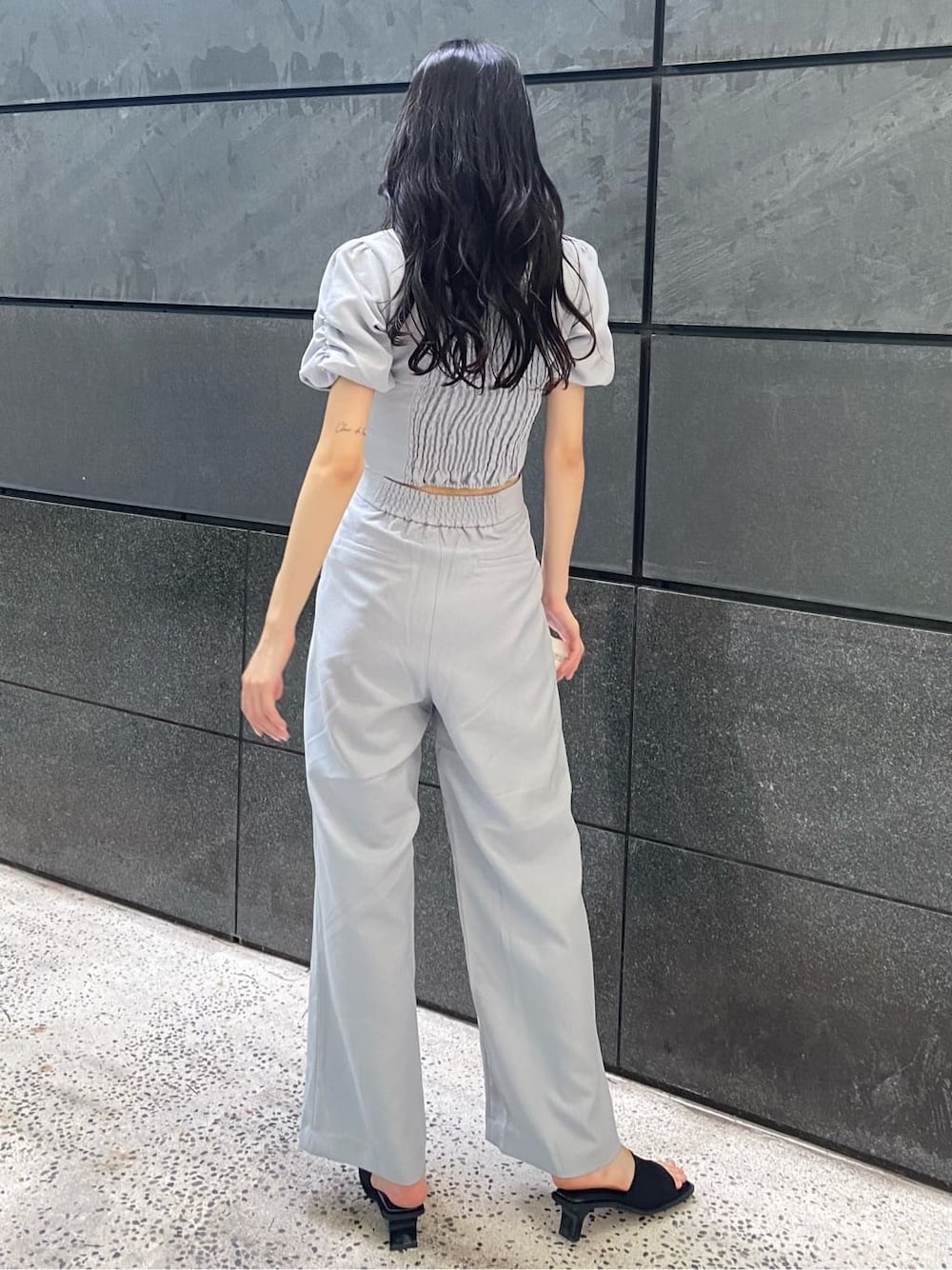 グレー系のTシャツ/カットソー、グレー系のその他パンツ、ブラック系のサンダルを着用したレディースの夏コーディネートの3枚目の写真