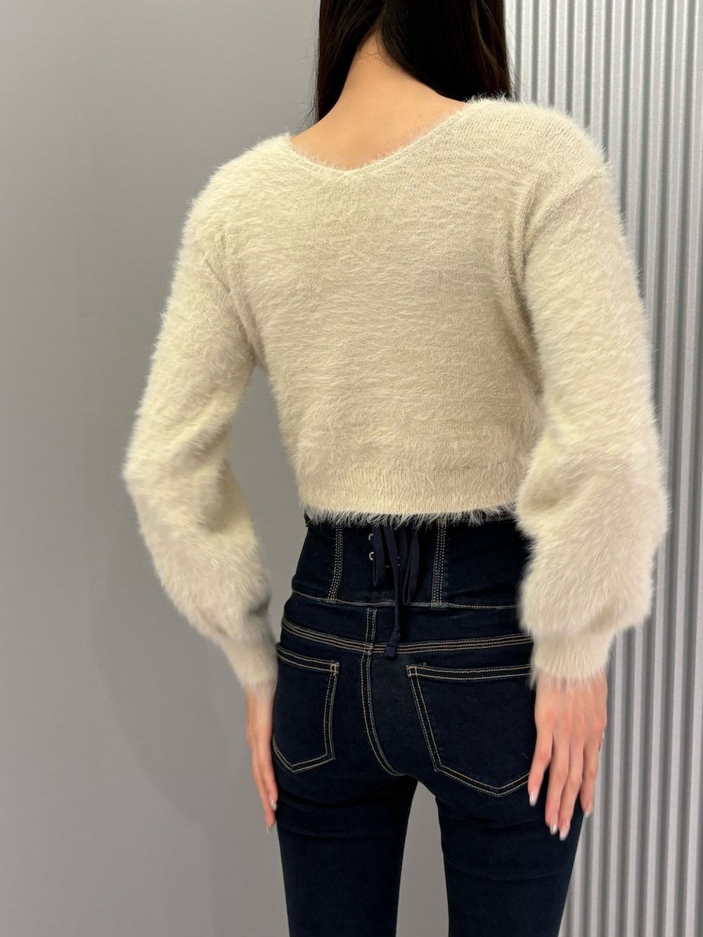 ブルー系のデニムパンツ、ブラック系のキャミソール、ホワイト系のニット/セーターを着用したレディースの秋コーディネートの8枚目の写真