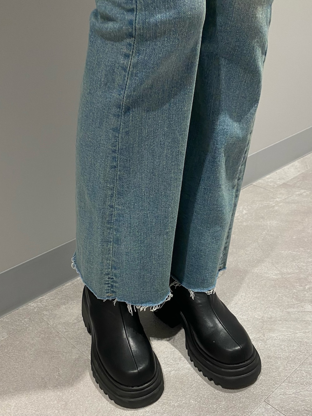 ブラック系のブルゾン、ブルー系のデニムパンツ、ホワイト系のニット/セーターを着用したレディースの冬コーディネートの8枚目の写真