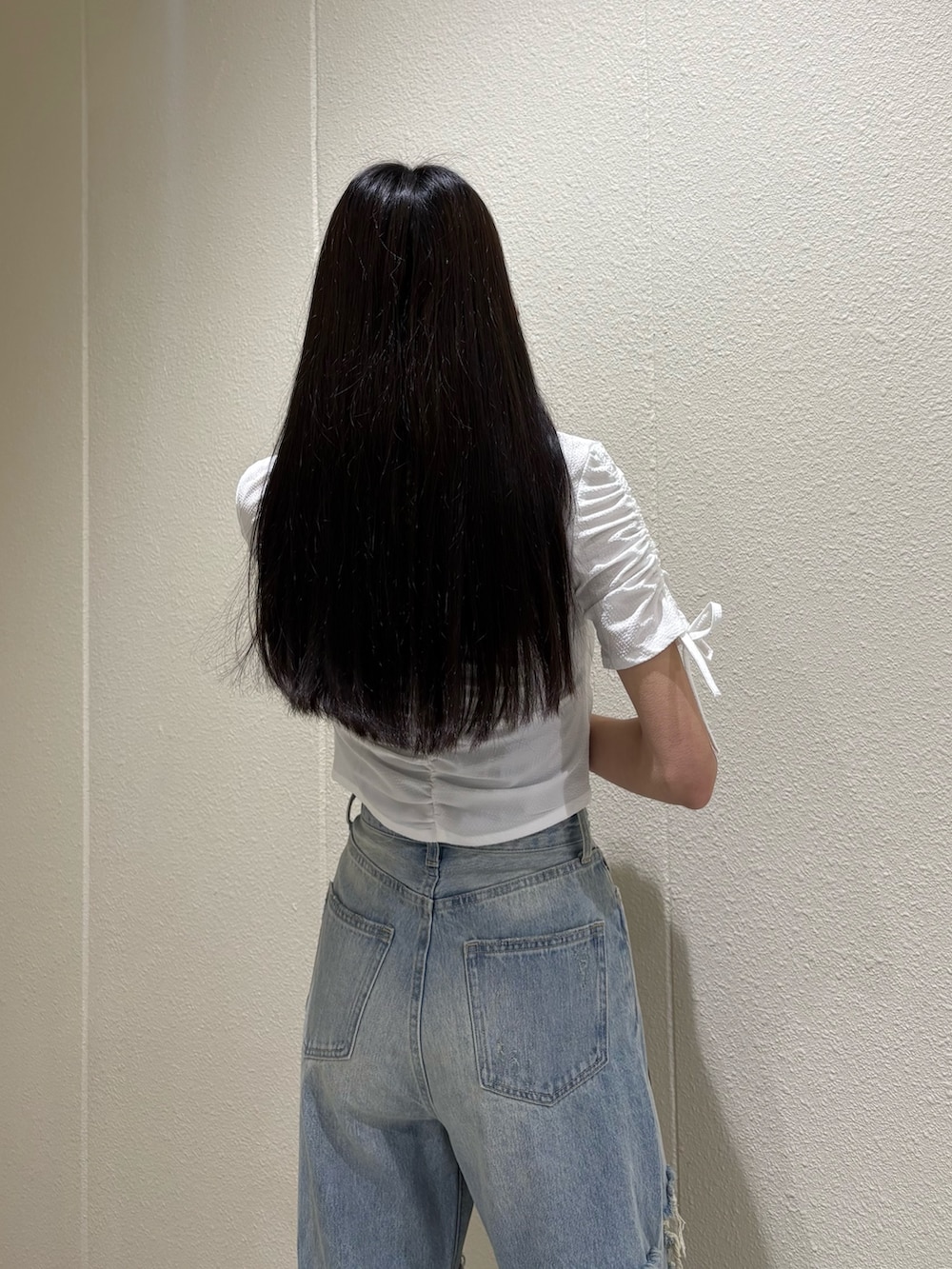 ブルー系のデニムパンツ、ホワイト系のシャツ/ブラウス、ブラック系のサンダルを着用したレディースの春コーディネートの7枚目の写真