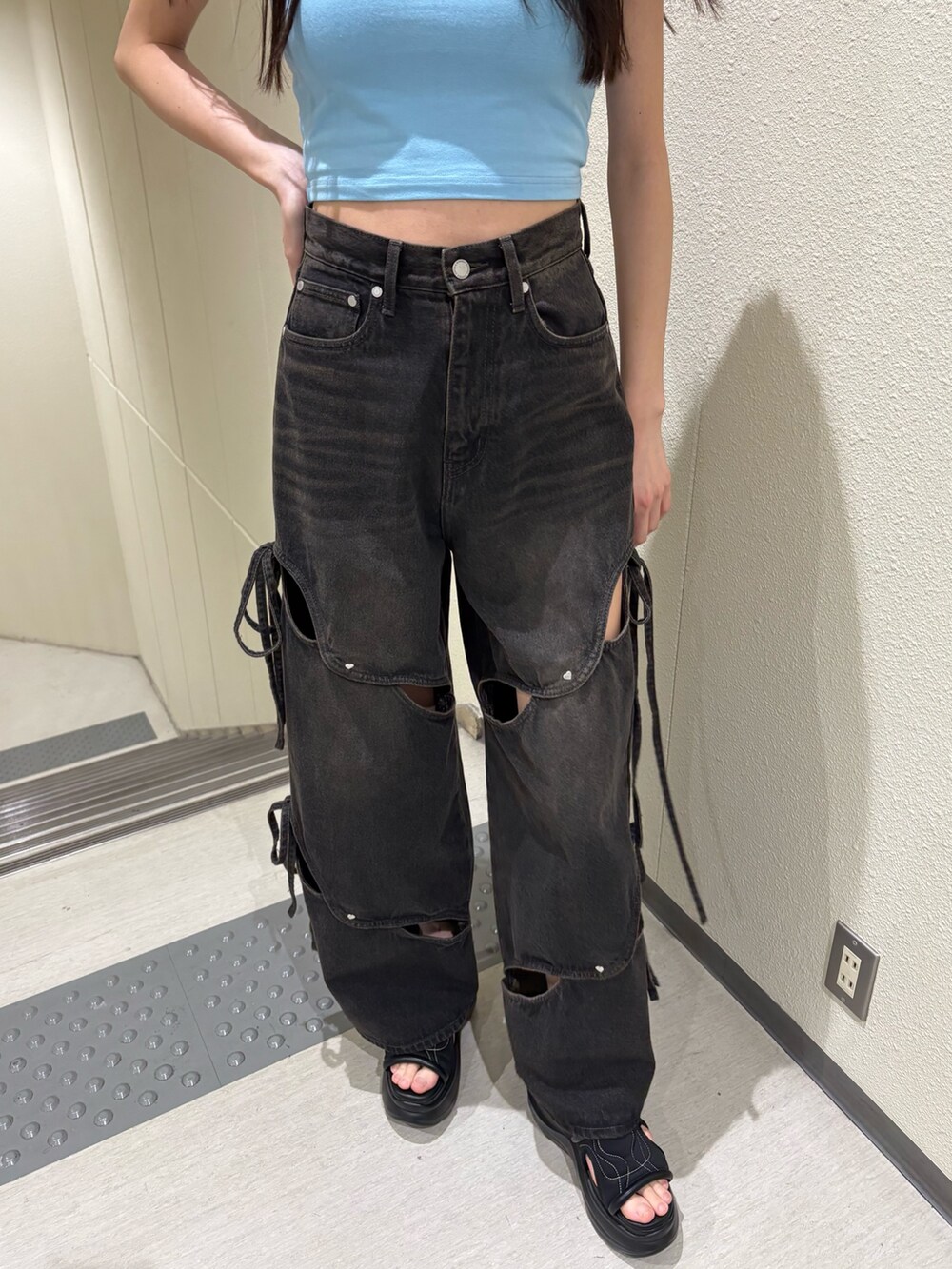 ブルー系のTシャツ/カットソー、ブラック系のデニムパンツ、ブラック系のサンダルを着用したレディースの春コーディネートの7枚目の写真