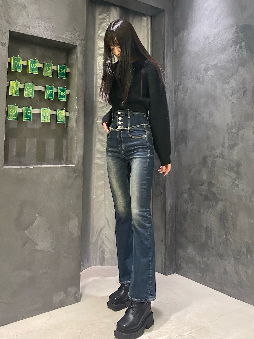 ブルー系のデニムパンツ、ブラック系のニット/セーター、ブラック系のブーツを着用したレディースの秋コーディネートの7枚目の写真