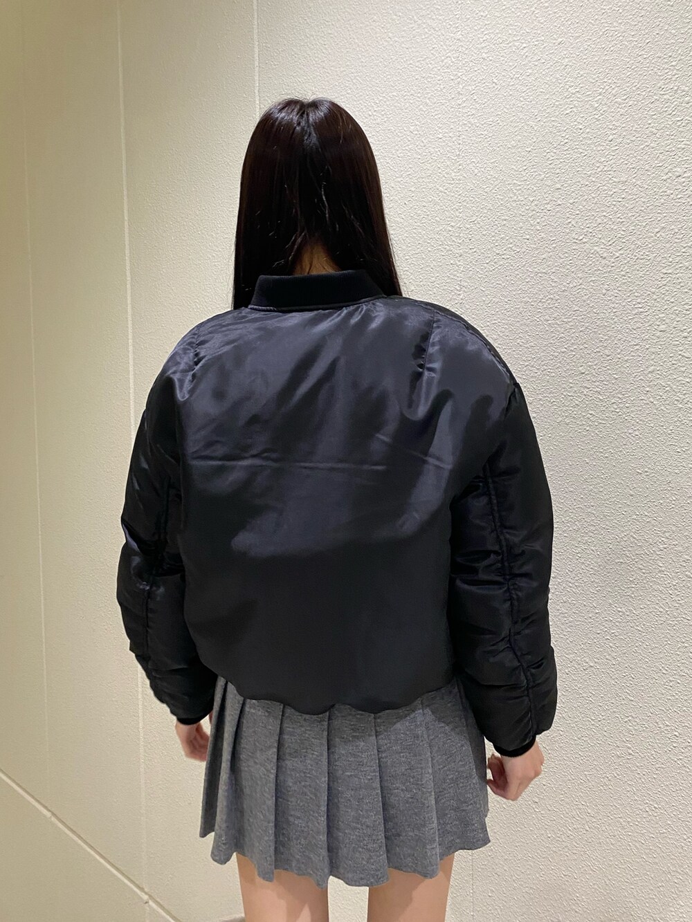 グレー系のスカート、ブラック系のブルゾン、その他のブーツを着用したレディースの秋コーディネートの8枚目の写真