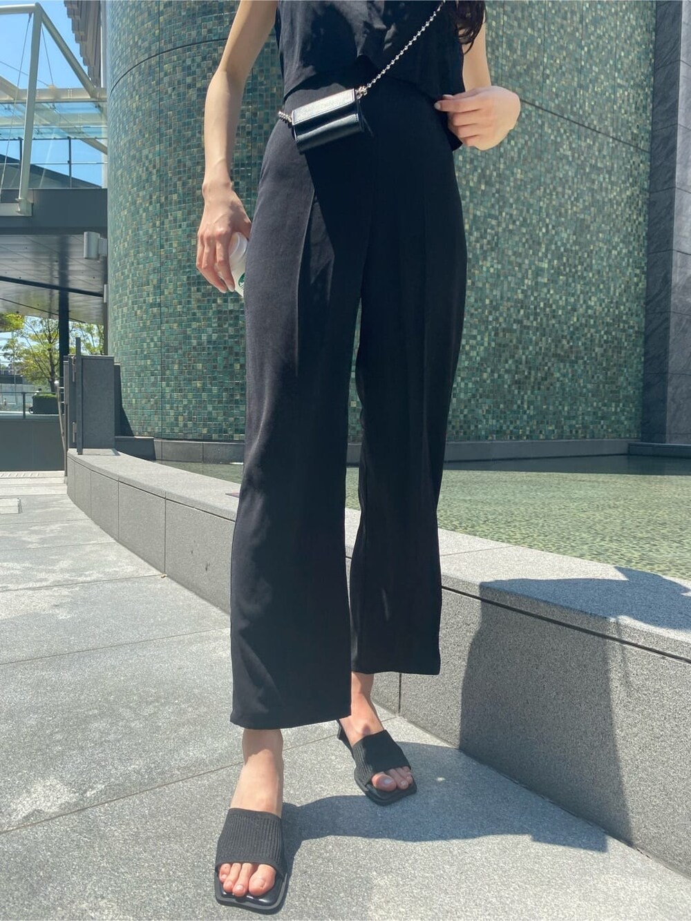 ブラック系のつなぎ/オールインワン、ブラック系のサンダル、ブラック系の財布を着用したレディースの夏コーディネートの6枚目の写真