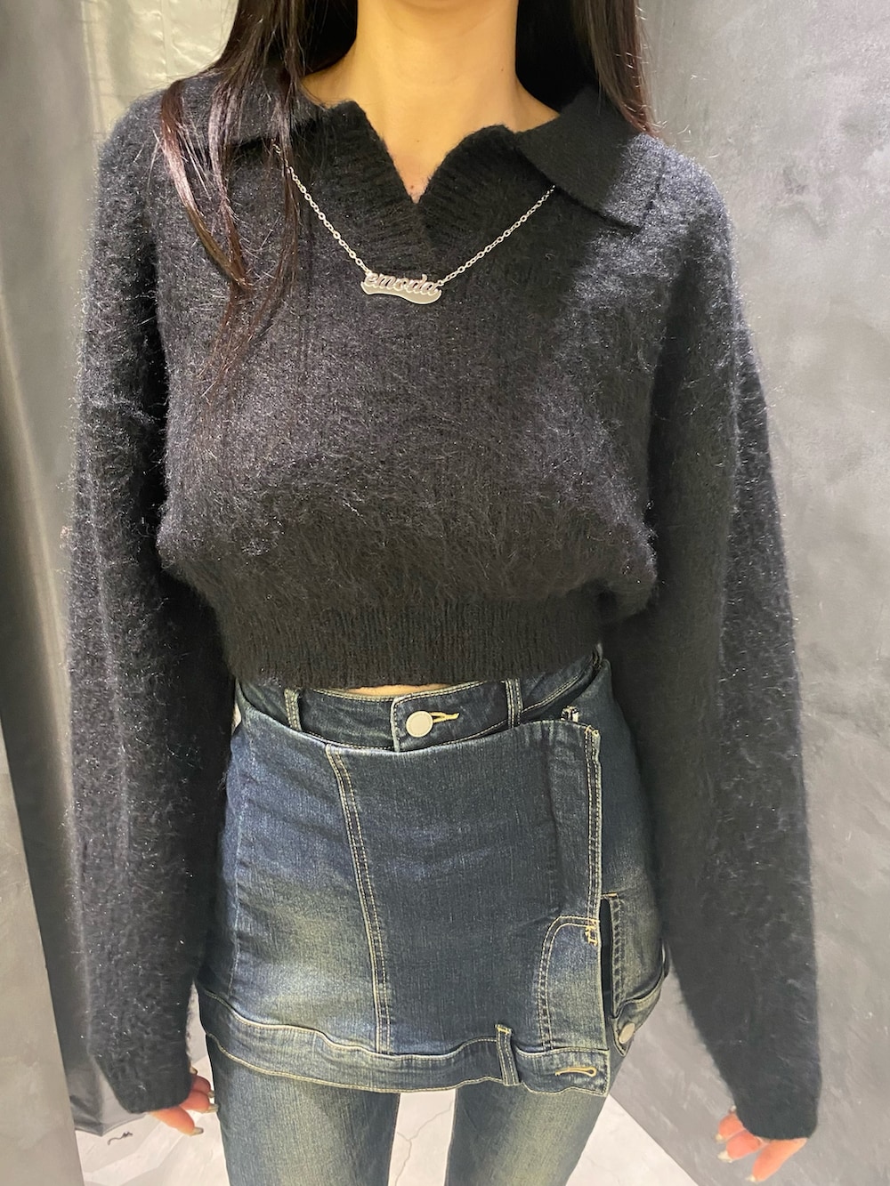 ブルー系のデニムパンツ、ブラック系のニット/セーター、ブラック系のブーツを着用したレディースの秋コーディネートの8枚目の写真