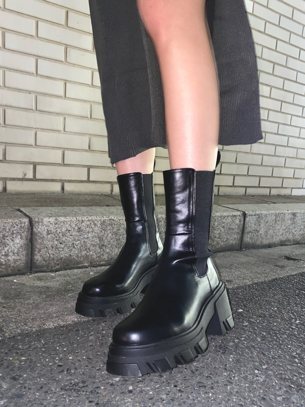 グレー系のワンピース、ブラック系のブーツを着用したレディースの秋コーディネートの5枚目の写真