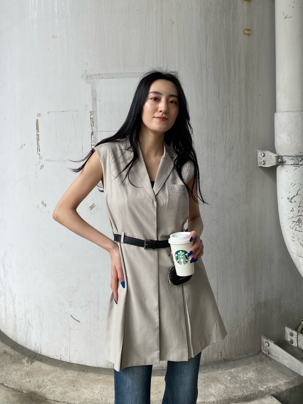 ホワイト系のワンピース、ブルー系のデニムパンツ、ブラック系のサンダルを着用したレディースの春コーディネートの6枚目の写真