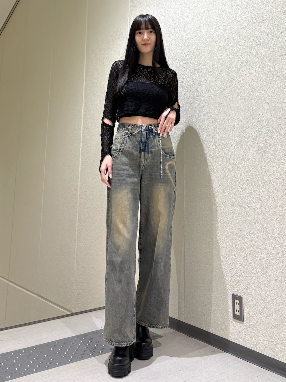 ブルー系のデニムパンツ、ブラック系のTシャツ/カットソー、ブラック系のブーツを着用したレディースの春コーディネートの2枚目の写真