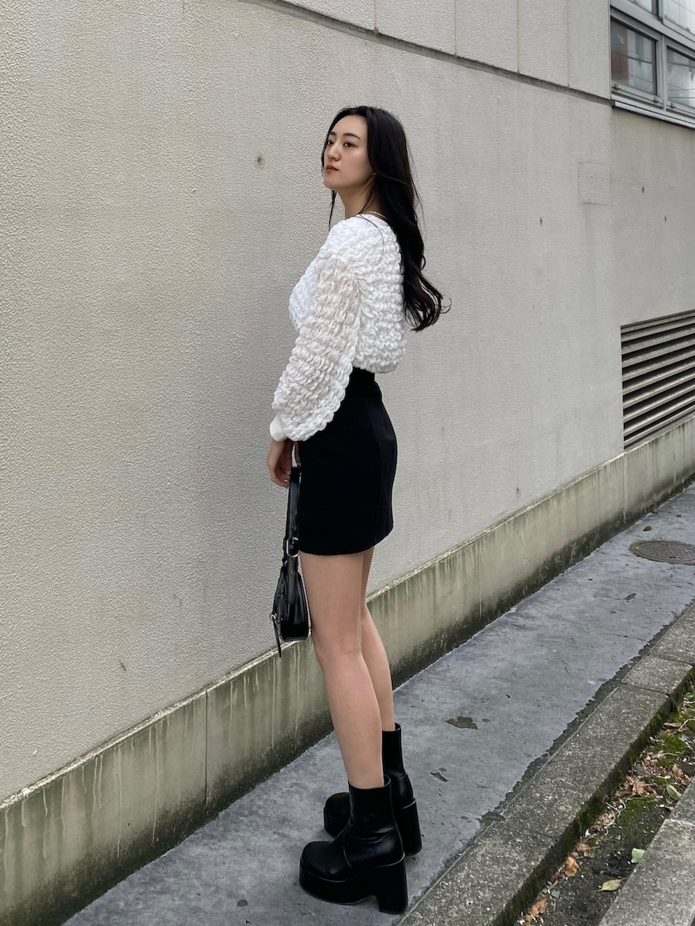 ホワイト系のTシャツ/カットソー、ブラック系のスカート、ブラック系のハンドバッグを着用したレディースの春コーディネートの2枚目の写真