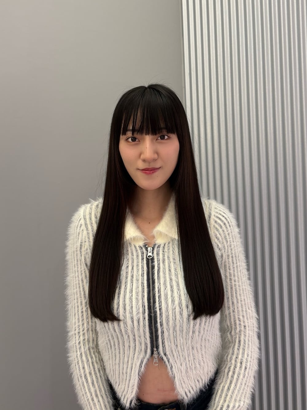 ブルー系のデニムパンツ、ホワイト系のニット/セーター、ブラック系のブーツを着用したレディースの秋コーディネートの6枚目の写真