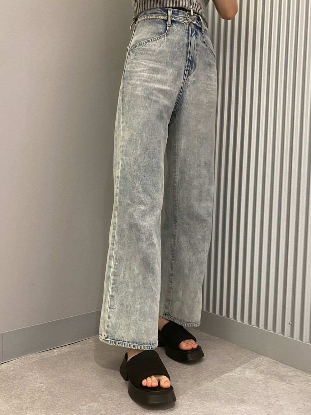 ブルー系のデニムパンツ、グレー系のニット/セーター、ブラック系のサンダルを着用したレディースの春コーディネートの9枚目の写真