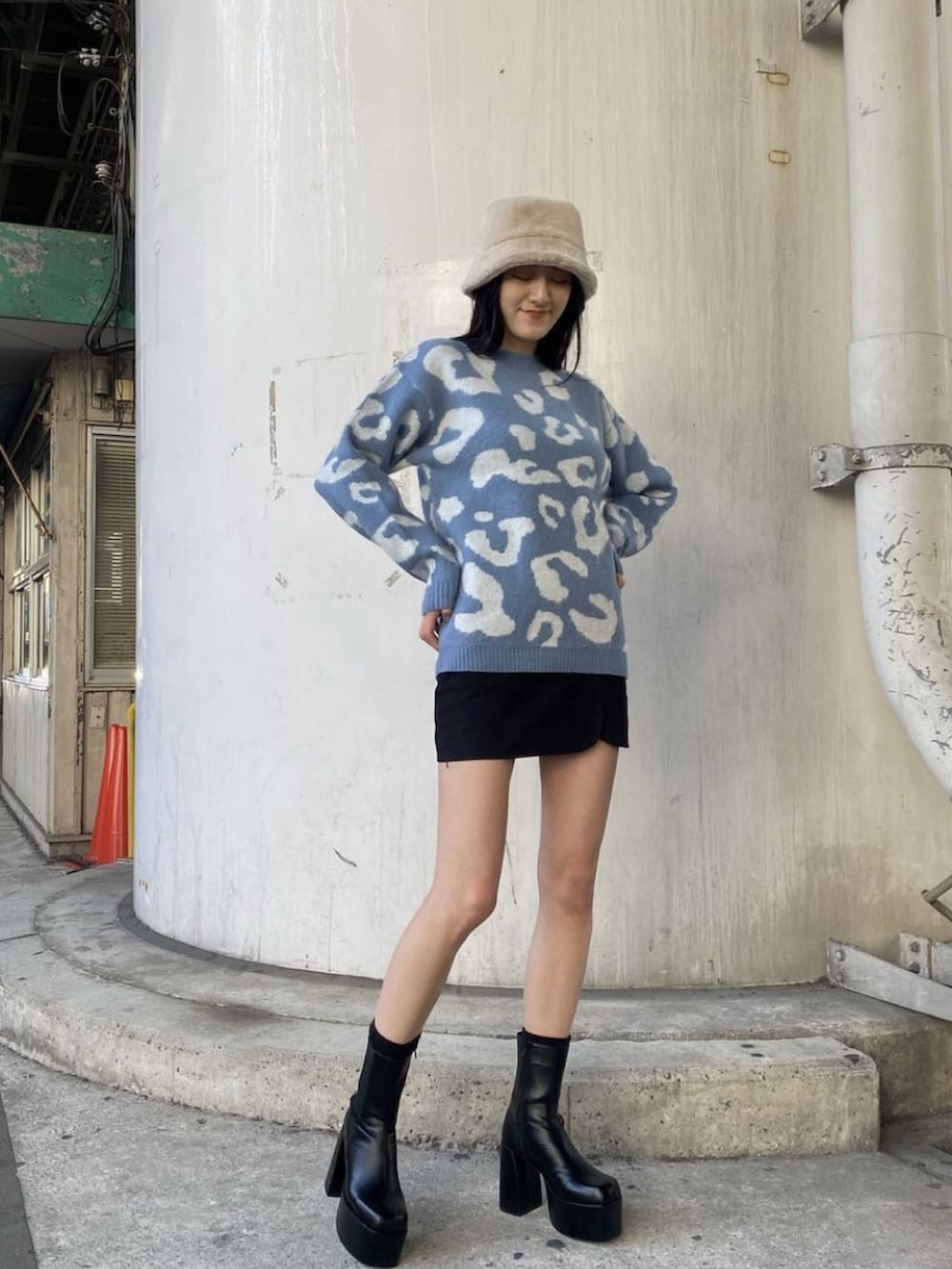 ブルー系のニット/セーター、ブラック系のスカート、ブラック系のブーツを着用したレディースの冬コーディネートの2枚目の写真