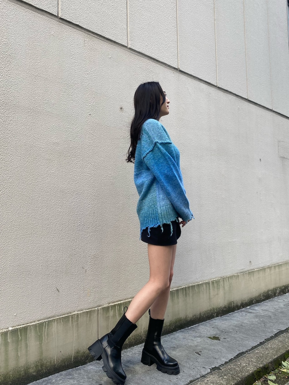 ブルー系のニット/セーター、ブラック系のブーツ、ホワイト系のダウンジャケット/コートを着用したレディースの冬コーディネートの5枚目の写真