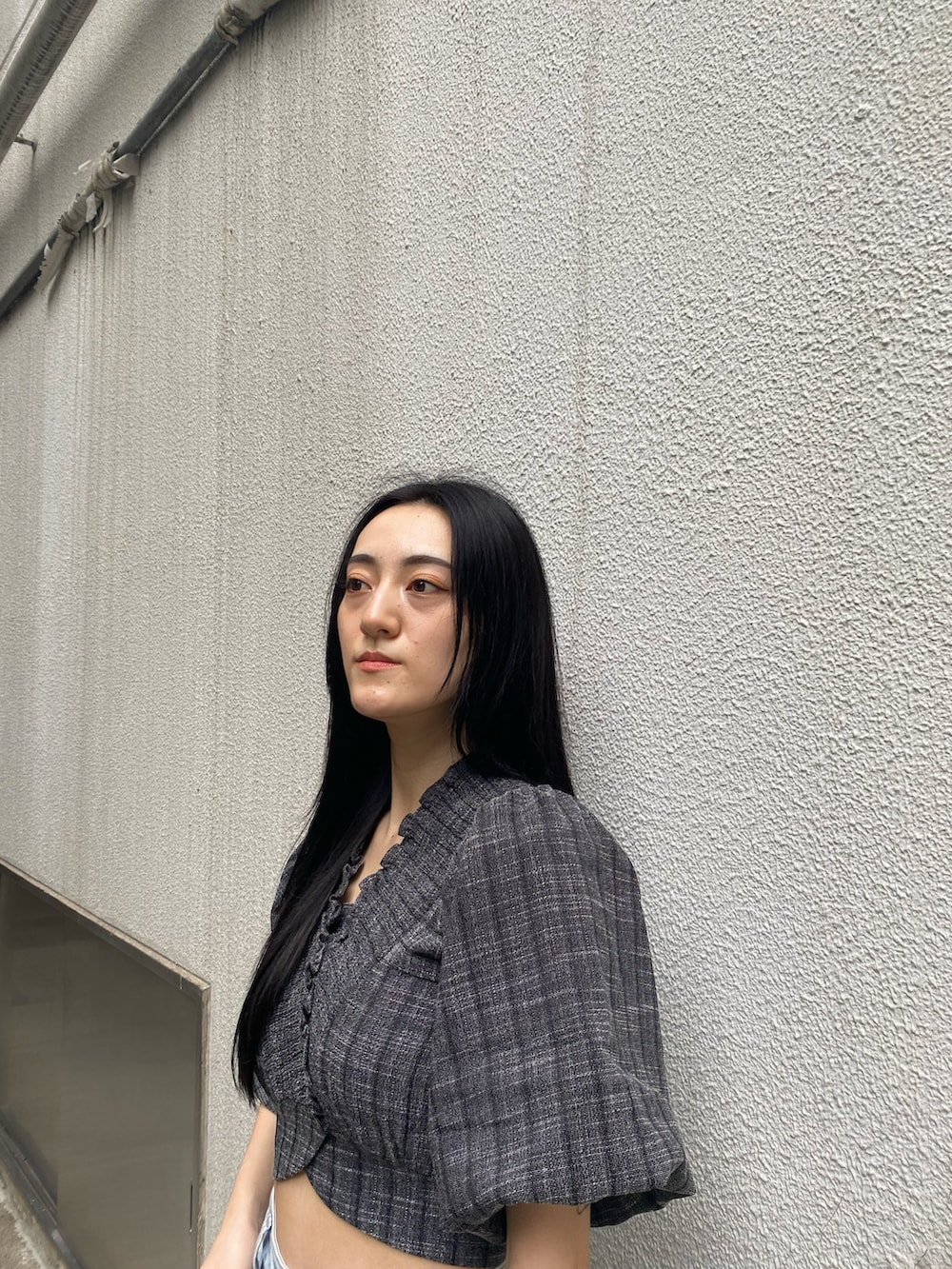 ブラック系のショルダーバッグ、ブラック系のTシャツ/カットソー、ブルー系のデニムパンツを着用したレディースの夏コーディネートの5枚目の写真