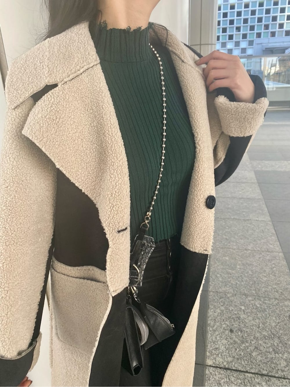 ブラック系のデニムパンツ、ブラック系のムートンコート、ブラック系のショルダーバッグを着用したレディースの冬コーディネートの5枚目の写真