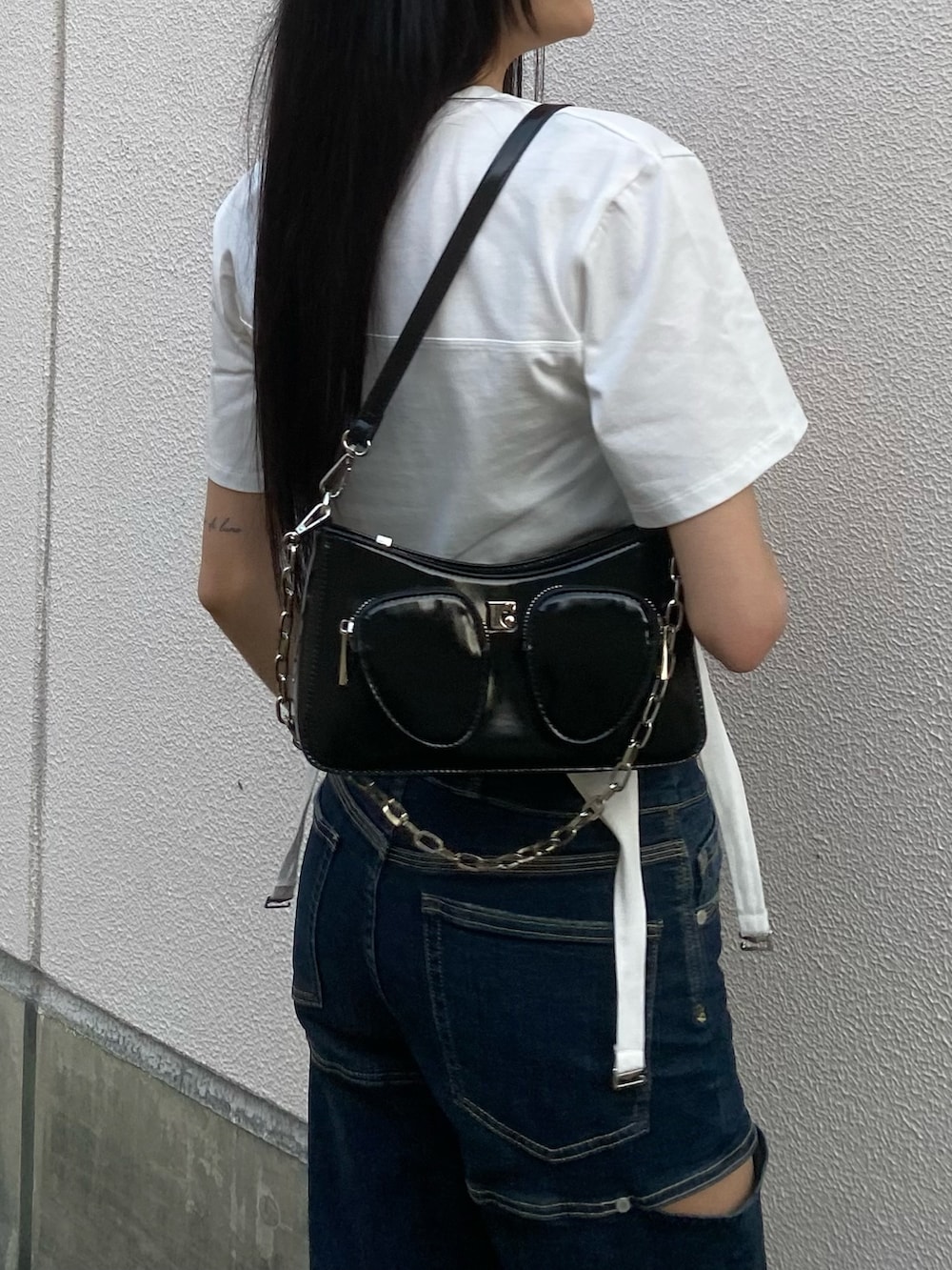 ブルー系のデニムパンツ、ブラック系のショルダーバッグ、ホワイト系のTシャツ/カットソーを着用したレディースの春コーディネートの5枚目の写真