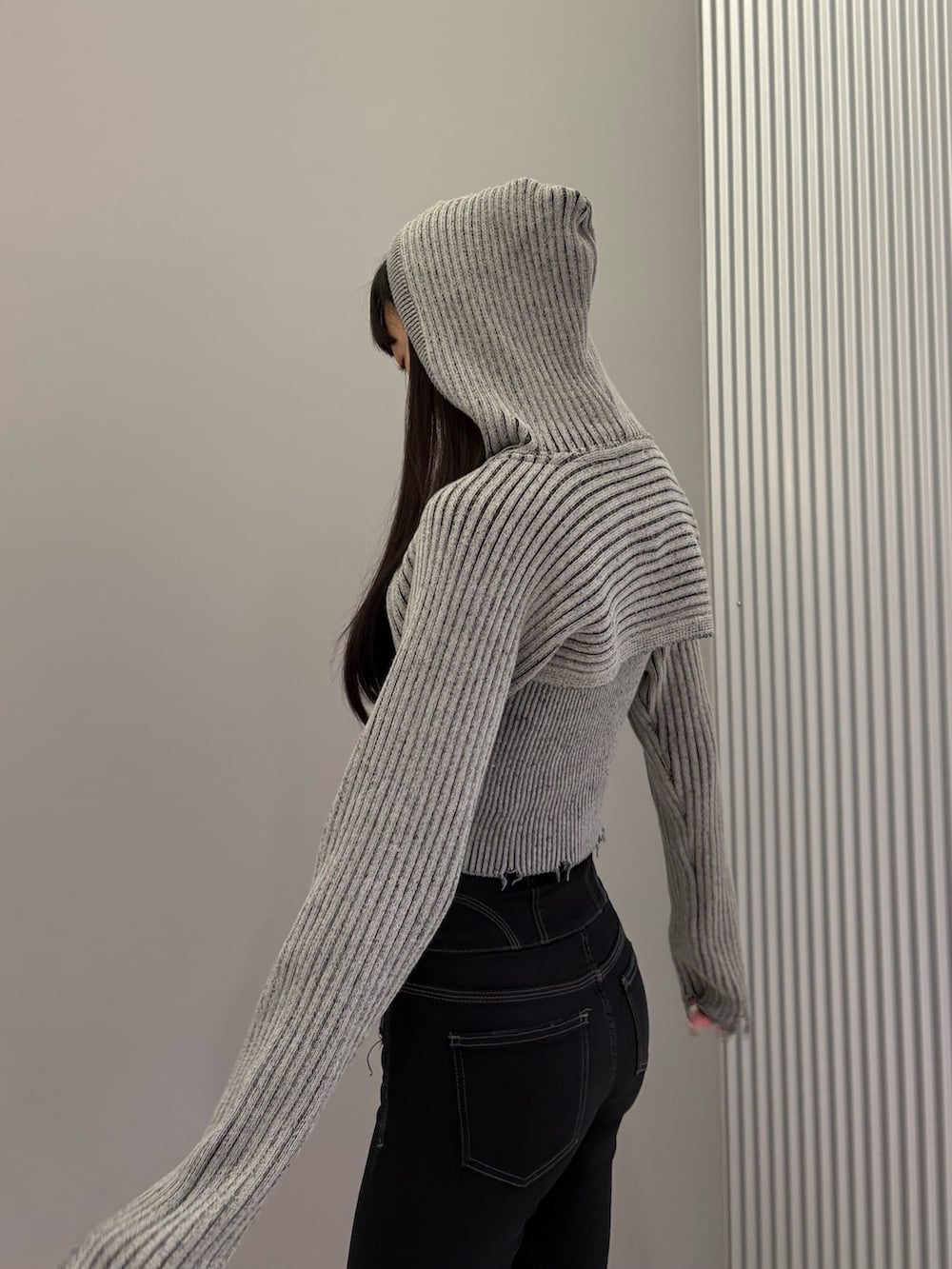 ブラック系のデニムパンツ、ブラック系のブーツ、グレー系のニット/セーターを着用したレディースの秋コーディネートの8枚目の写真