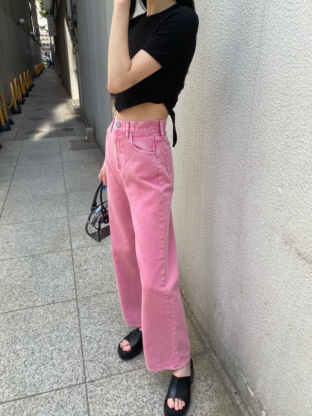 ピンク系のデニムパンツ、ブラック系のTシャツ/カットソー、その他のハンドバッグを着用したレディースの春コーディネートの7枚目の写真