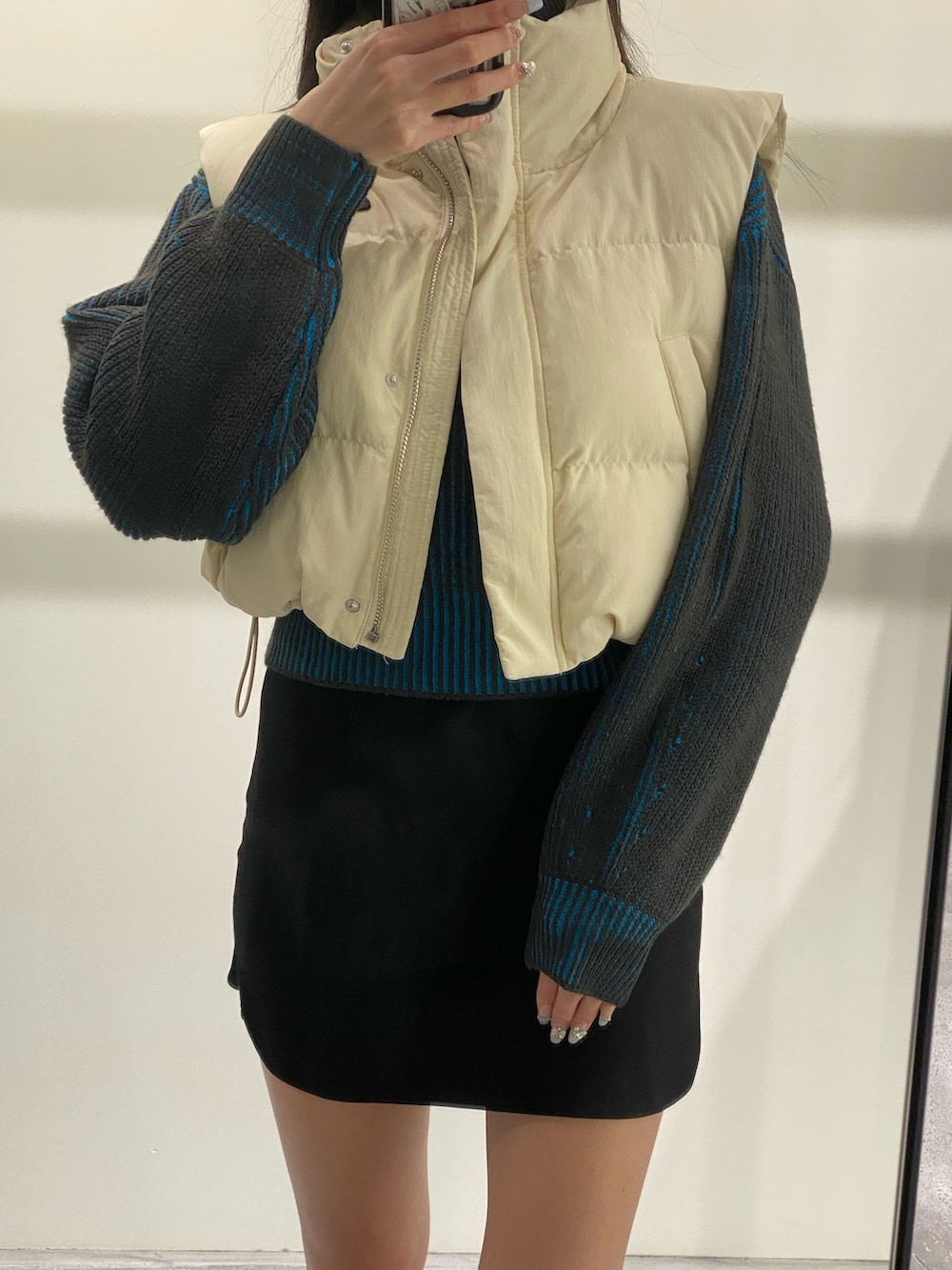 ブラック系のスカート、ブラック系のブーツ、ブルー系のニット/セーターを着用したレディースの秋コーディネートの3枚目の写真