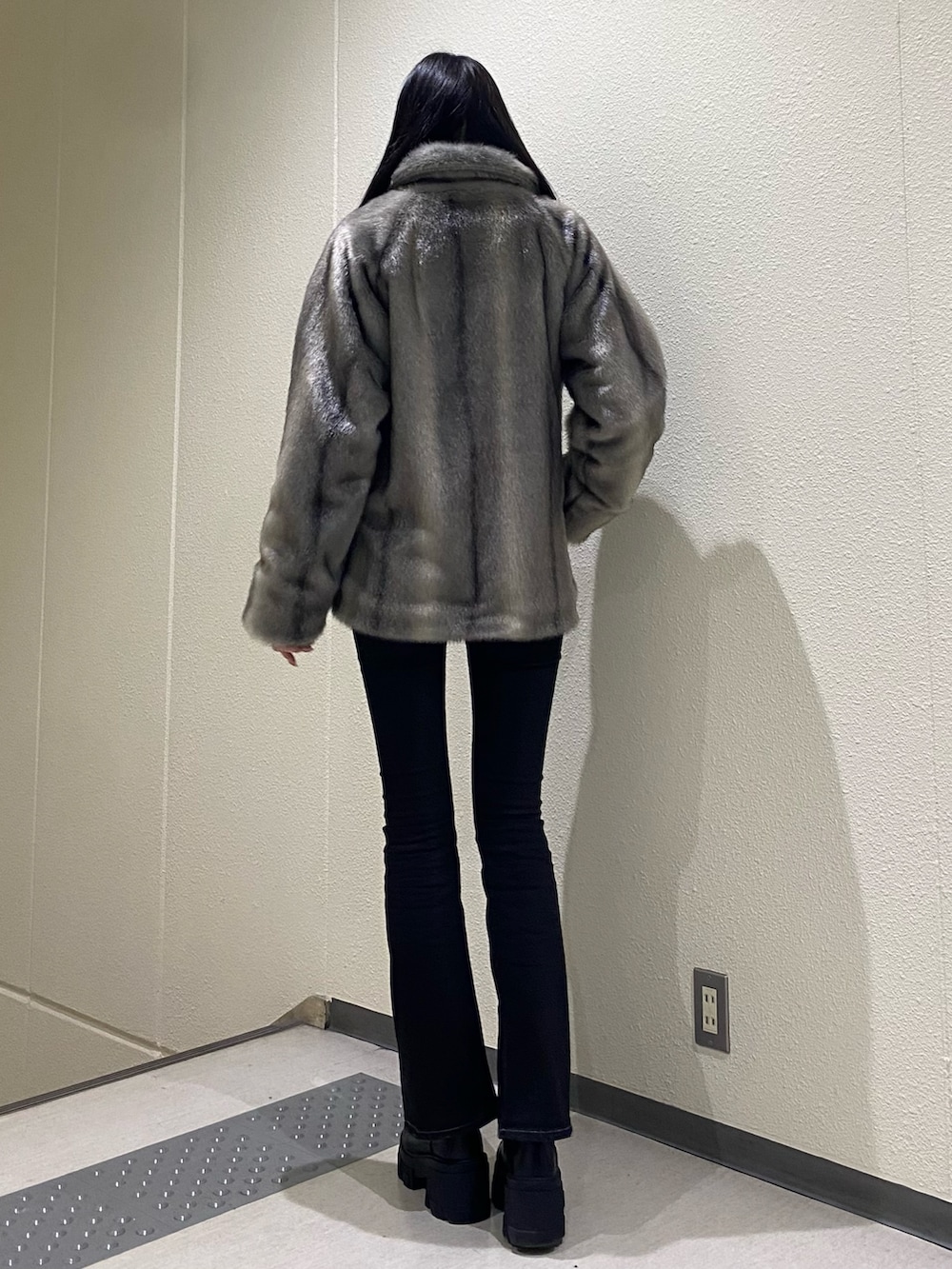 ブラック系のデニムパンツ、ブラック系のブーツ、ブラック系のニット/セーターを着用したレディースの冬コーディネートの3枚目の写真