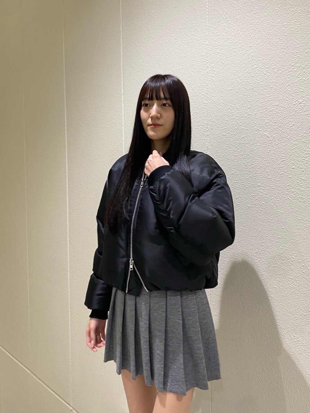 グレー系のスカート、ブラック系のブルゾン、その他のブーツを着用したレディースの秋コーディネートの7枚目の写真