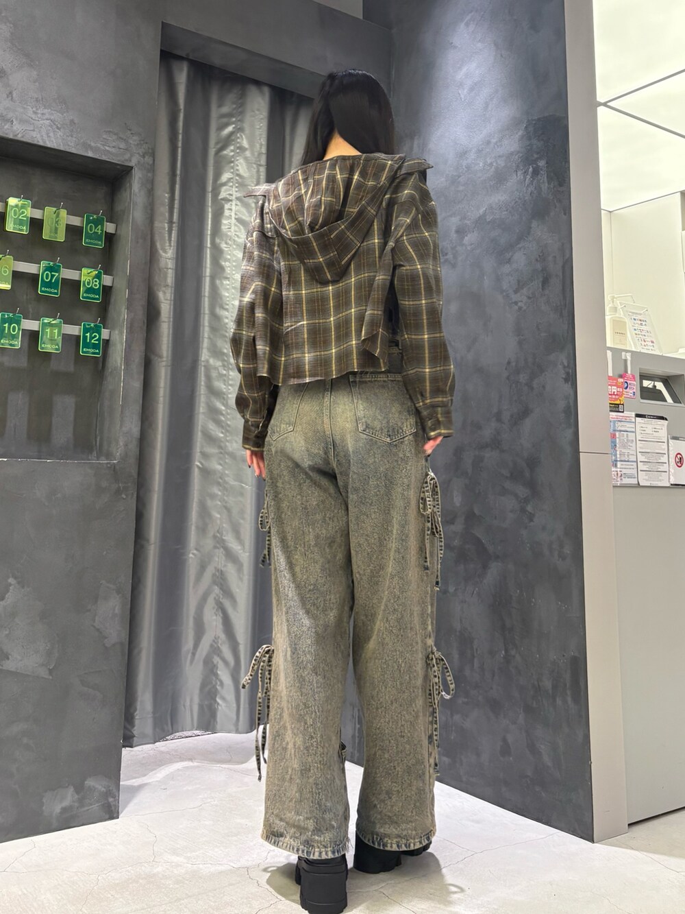 ブルー系のデニムパンツ、ブラック系のブーツ、グリーン系のシャツ/ブラウスを着用したレディースの夏コーディネートの4枚目の写真