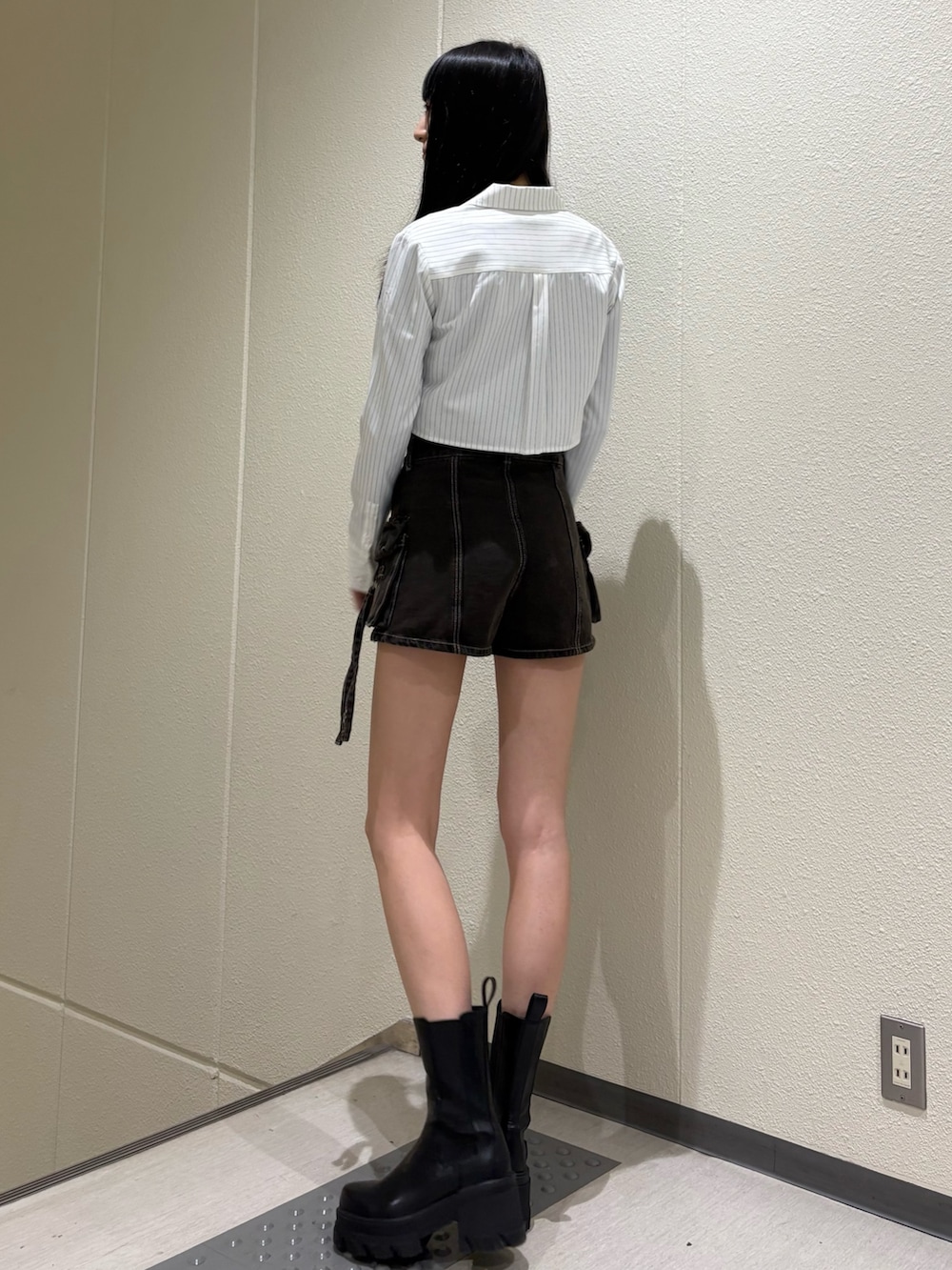 ブラック系のその他パンツ、ホワイト系のシャツ/ブラウス、ブラック系のブーツを着用したレディースの春コーディネートの2枚目の写真