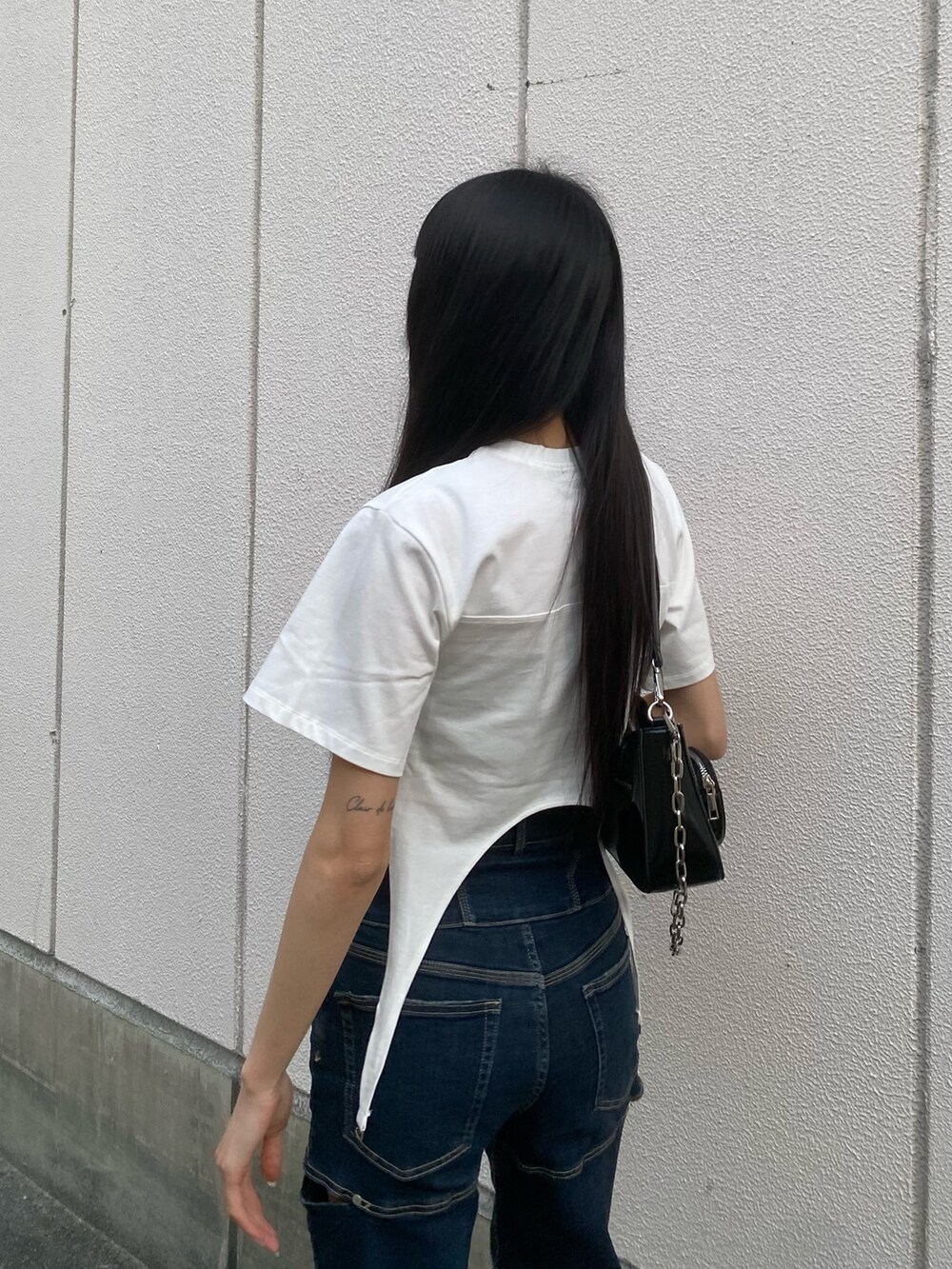 ブルー系のデニムパンツ、ブラック系のショルダーバッグ、ホワイト系のTシャツ/カットソーを着用したレディースの春コーディネートの6枚目の写真