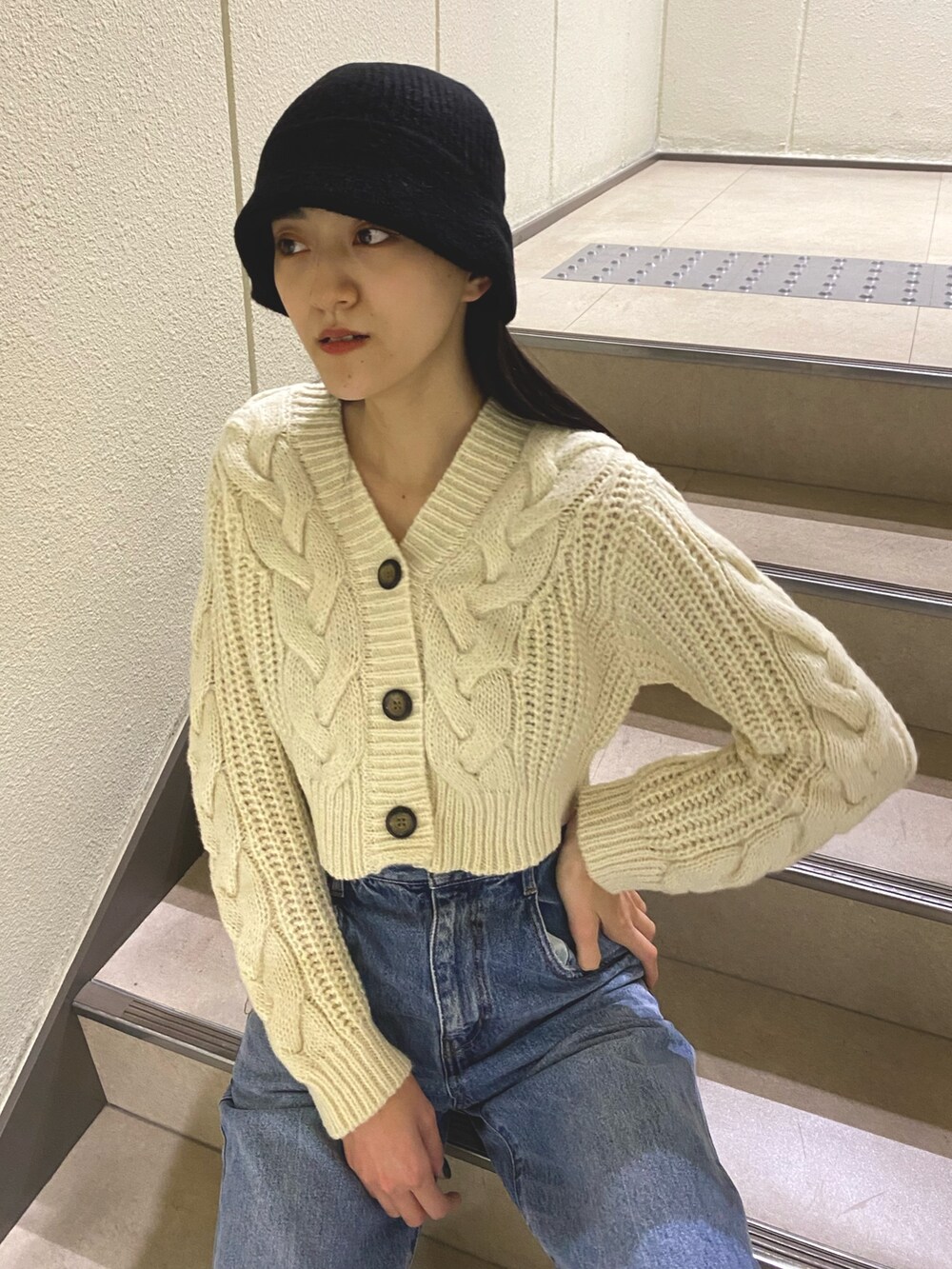 ブルー系のデニムパンツ、ホワイト系のカーディガン/ボレロ、ブラック系のハットを着用したレディースの秋コーディネートの5枚目の写真