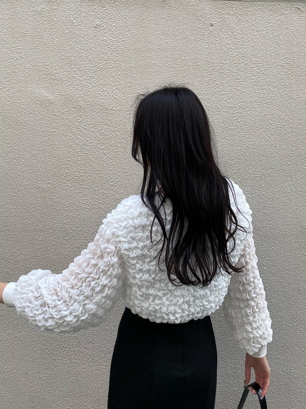 ホワイト系のTシャツ/カットソー、ブラック系のスカート、ブラック系のハンドバッグを着用したレディースの春コーディネートの4枚目の写真