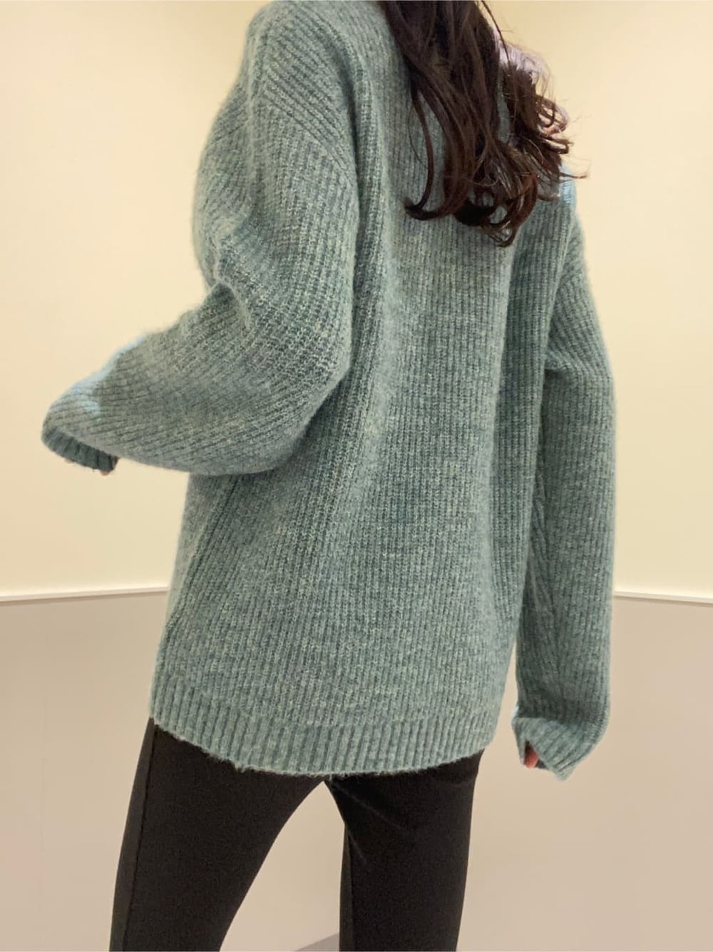 ブラック系のハンドバッグ、ブルー系のニット/セーター、ブラック系のその他パンツを着用したレディースの秋コーディネートの6枚目の写真