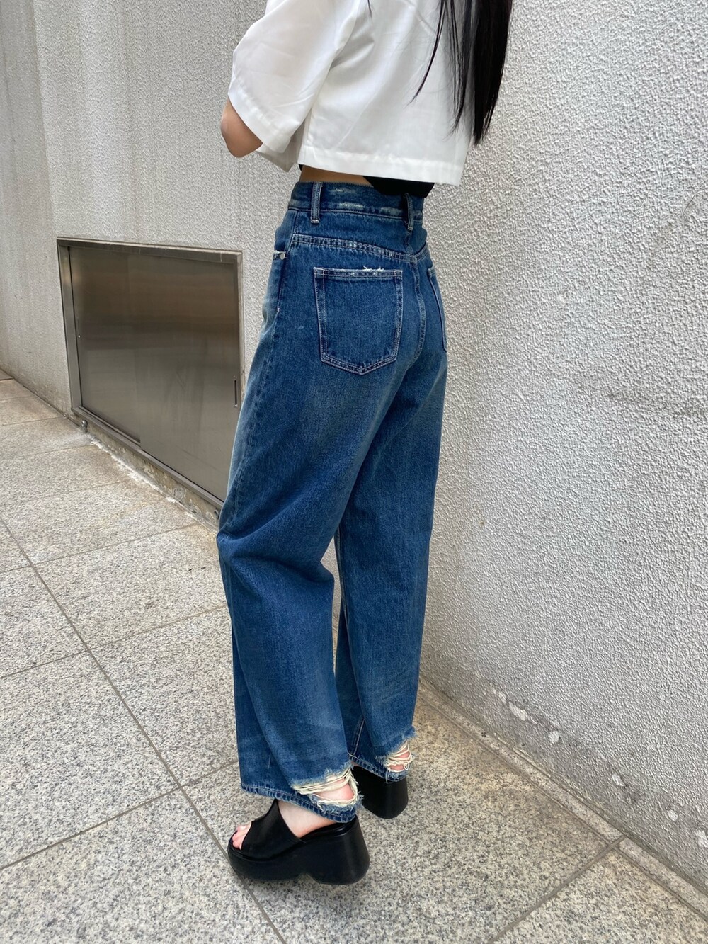 ブルー系のデニムパンツ、ブラック系のニット/セーター、ホワイト系のシャツ/ブラウスを着用したレディースの春コーディネートの8枚目の写真