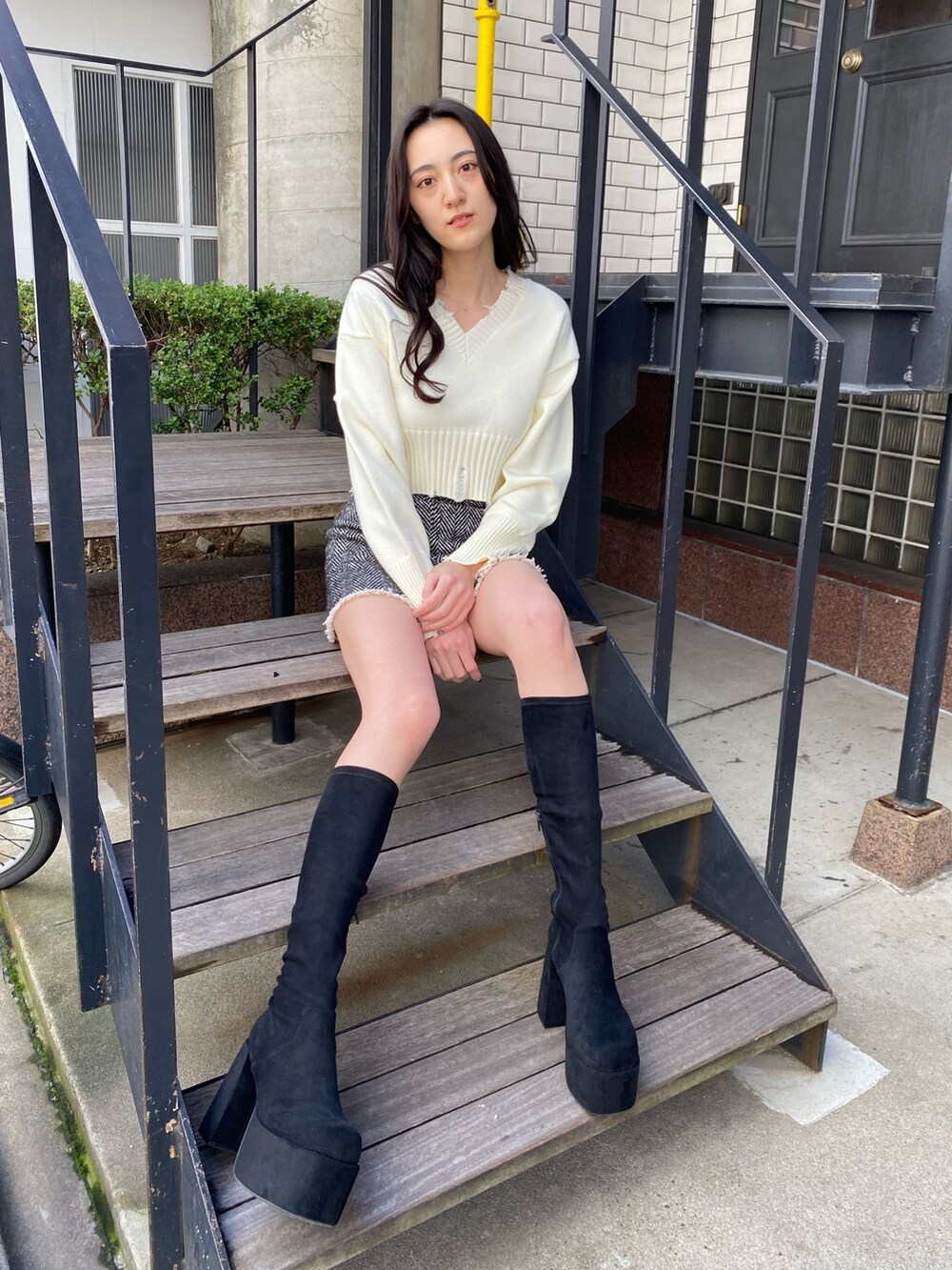 ホワイト系のニット/セーター、ブラック系のブーツを着用したレディースの冬コーディネートの2枚目の写真